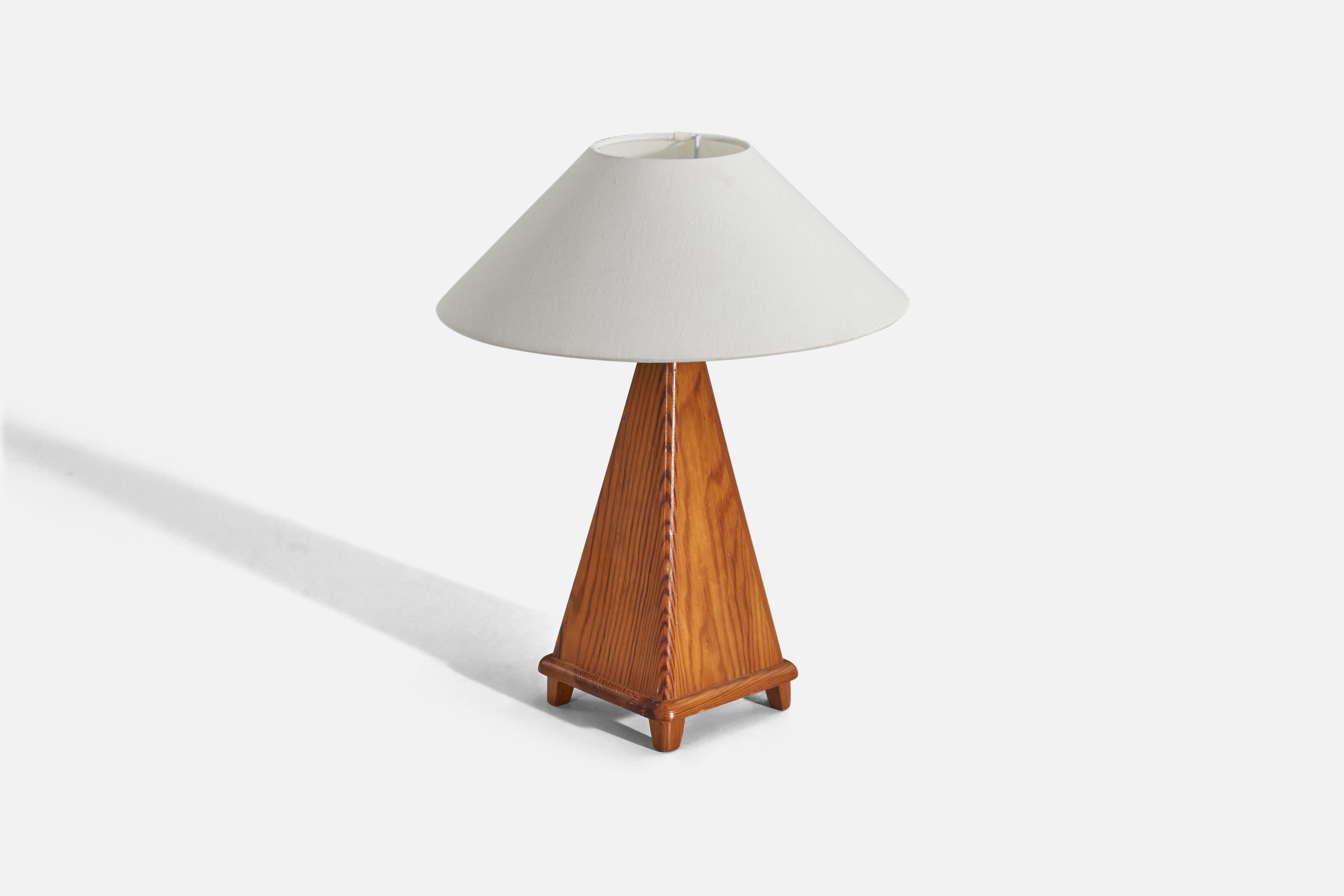 A pine table lamp designed and produced in Sweden, c. 1950s. 

Sold with fabric lampshade. 
Dimensions of lamp (inches) : 12.75 x 5 x 5 (height x width x depth).
Dimensions of shade (inches) : 3.91 x 11.75 x 5.5 (top diameter x bottom diameter x