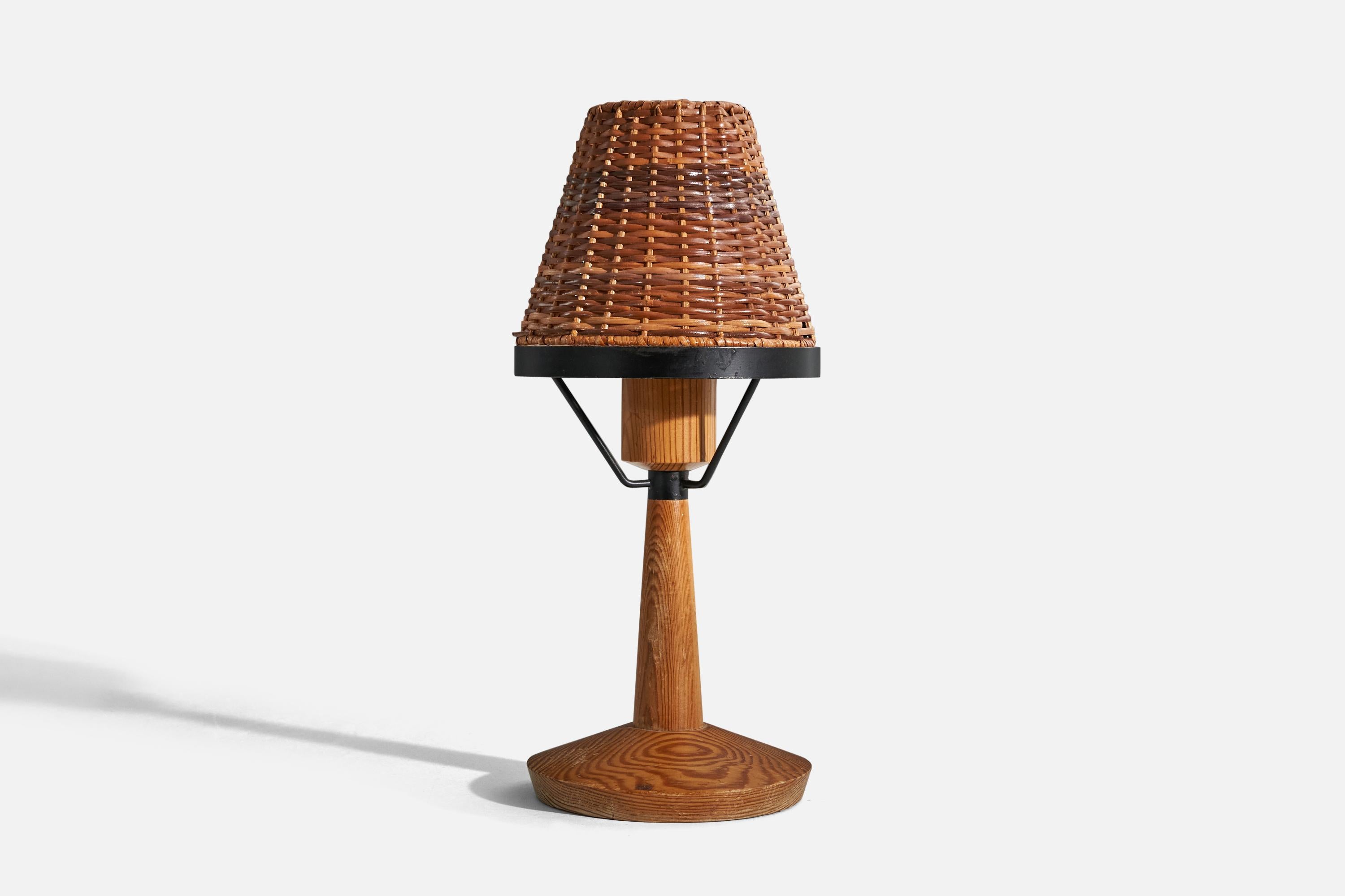 A pine, rattan and metal table lamp designed and produced in Sweden, c. 1970s.

Sold without lampshade. 
Dimensions of Lamp (inches) : 9.31 x 6 x 6 (H x W x D)
Dimensions of Shade (inches) : 3.12 x 5.75 x 4.87 (T x B x S)
Dimension of Lamp with