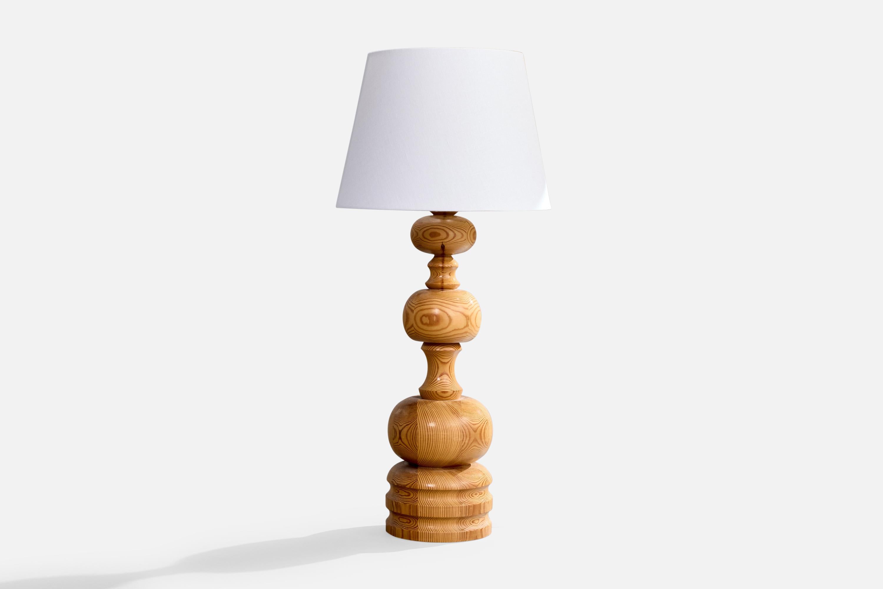 A sizable turned pine table lamp designed and produced in Sweden, c. 1970s.

Dimensions of Lamp (inches): 25“ H x 6.875“ Diameter

Dimensions of Shade (inches): 10“ Top Diameter x 14“ Bottom Diameter x 10“ H

Dimensions of Lamp with Shade (inches):