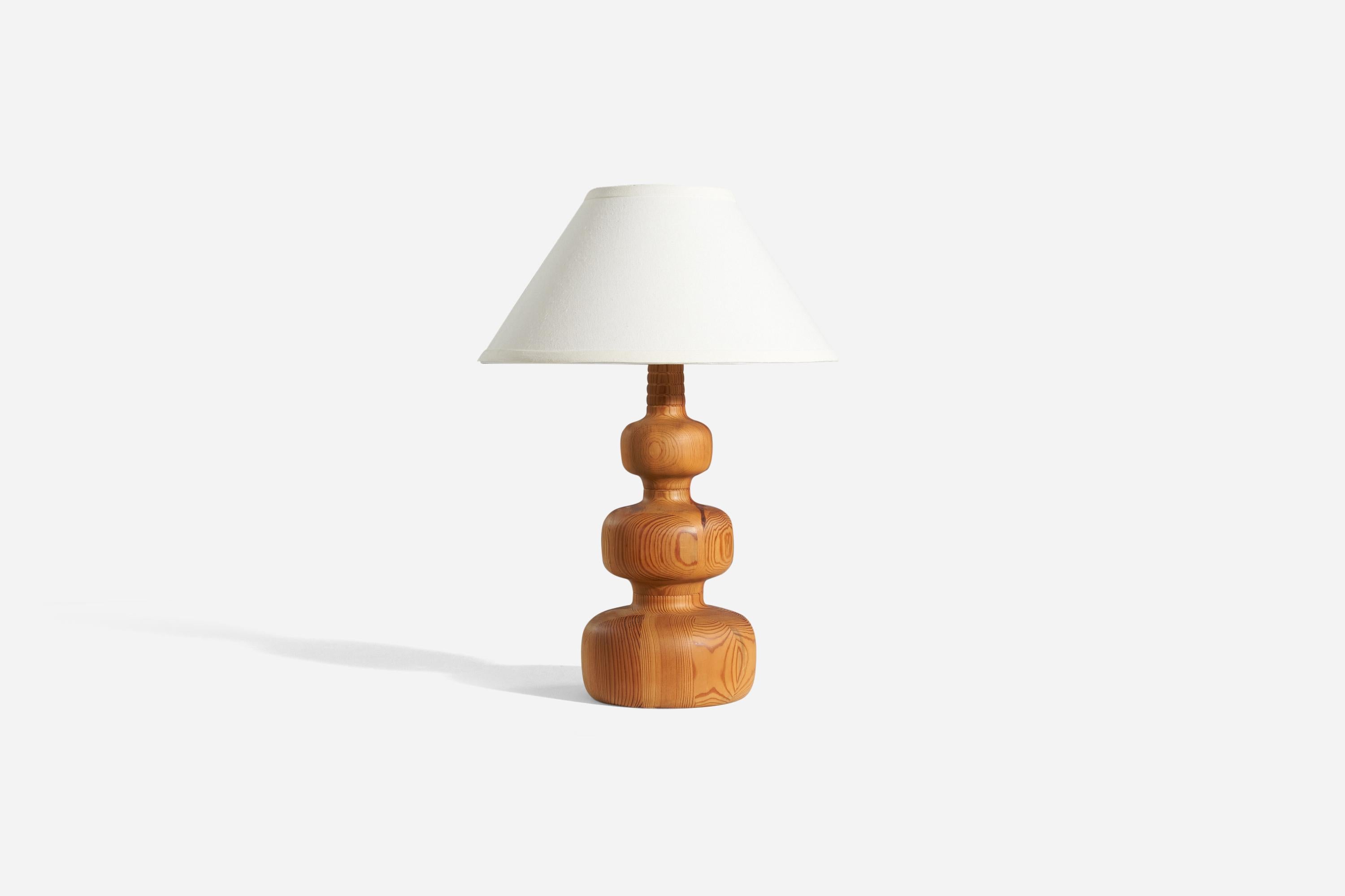 A stack laminated pine wood table lamp, designed and produced by a Swedish designer, Sweden, 1970s.

Sold without lampshade. 
Dimensions of lamp (inches) : 16.0625 x 6.75 x 6.75 (H x W x D)
Dimensions shade (inches) : 5.75 x 14 x 8 (T x B x