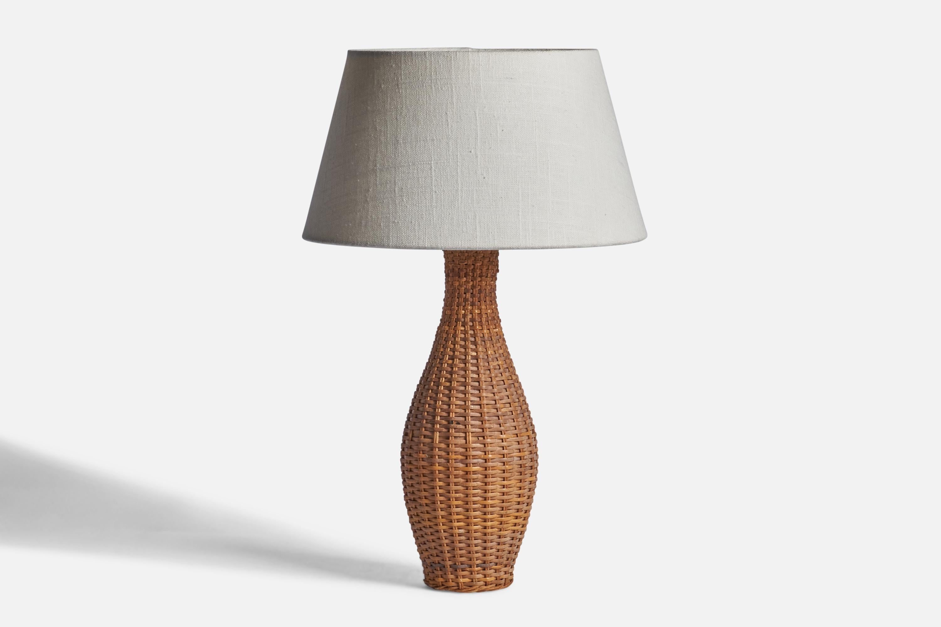 A woven rattan table lamp designed and produced in Sweden, 1960s.

Dimensions of Lamp (inches): 12.25” H x 3.75” Diameter
Dimensions of Shade (inches): 7” Top Diameter x 10” Bottom Diameter x 5.5” H 
Dimensions of Lamp with Shade (inches): 15.85” H