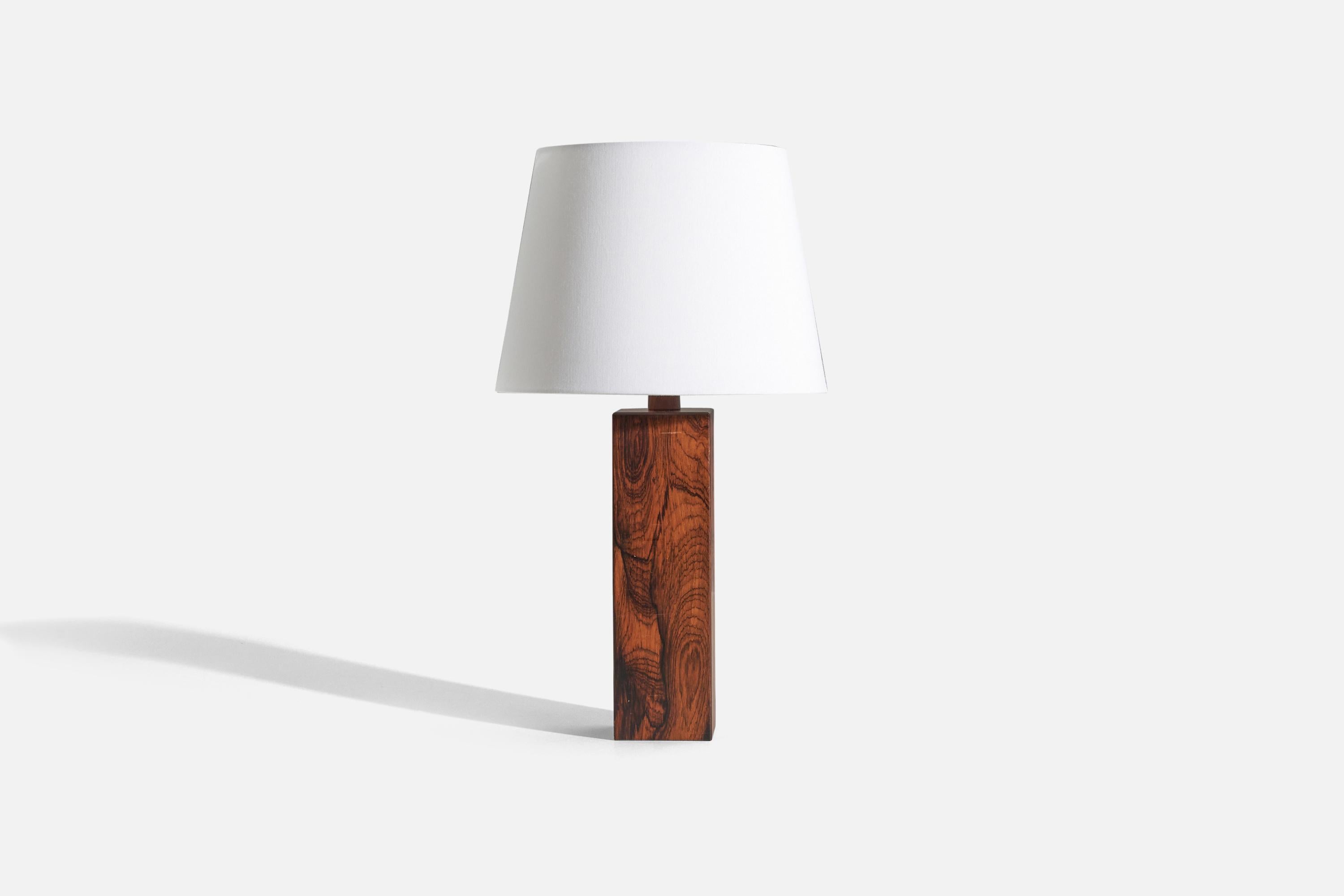 A rosewood table lamp designed and produced in Sweden, c. 1970s.

Sold without lampshade. 
Dimensions of lamp (inches) : 16.25 x 3.5 x 3.5 (H x W x D)
Dimensions of shade (inches) : 9 x 12 x 9 (T x B x H)
Dimension of lamp with shade (inches) :