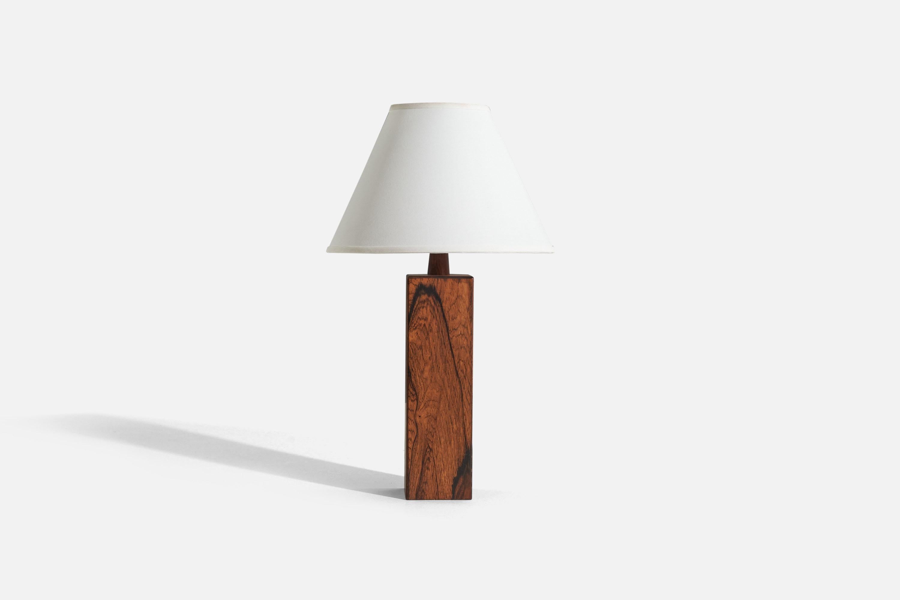 A rosewood table lamp designed and produced in Sweden, c. 1970s.

Sold without lampshade. 
Dimensions of Lamp (inches) : 16.25 x 3.5625 x 3.5625 (H x W x D)
Dimensions of Shade (inches) : 5 x 12.25 x 8.75 (T x B x H)
Dimension of Lamp with