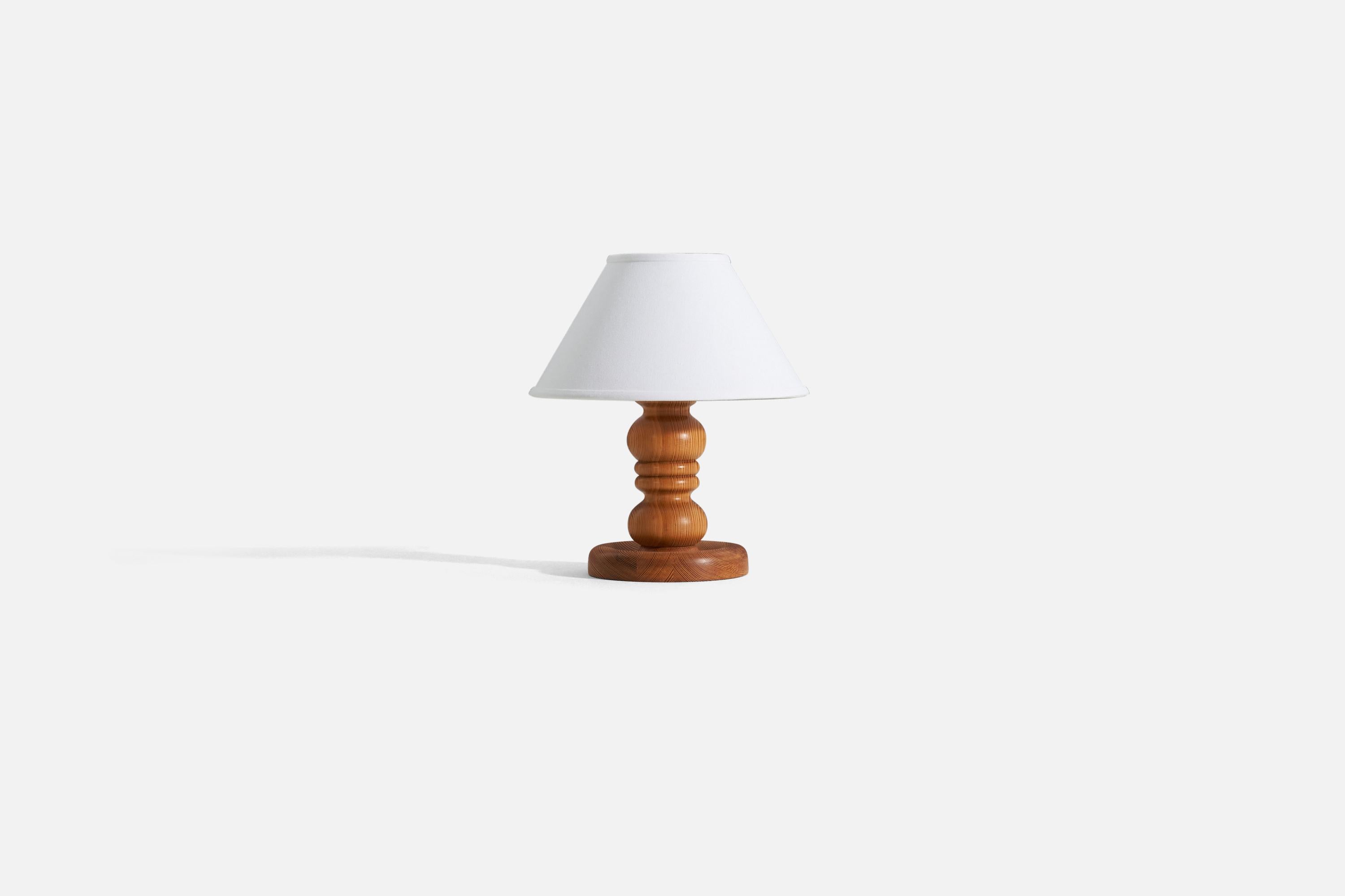 A solid, turned pine table lamp produced in Sweden, 1970s.

Sold without lampshade. 
Dimensions of Lamp (inches) : 11 x 7 x 7 (H x W x D)
Dimensions of Shade (inches) : 5 x 12.25 x 7.25 (T x B x H)
Dimension of Lamp with shade (inches) : 14.25