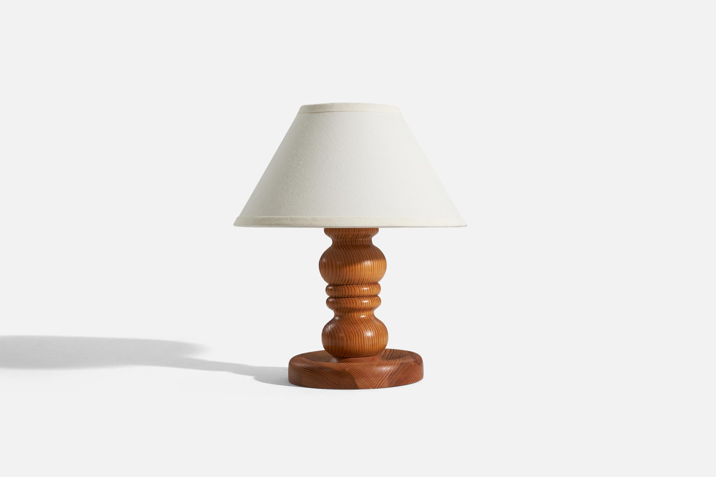 A solid pine table lamp designed and produced in Sweden, c. 1970s.

Sold without lampshade. 
Dimensions of Lamp (inches) : 11.1875 x 7 x 7 (H x W x D)
Dimensions of Shade (inches) : 5.25 x 12.25 x 7.25 (T x B x H)
Dimension of Lamp with Shade