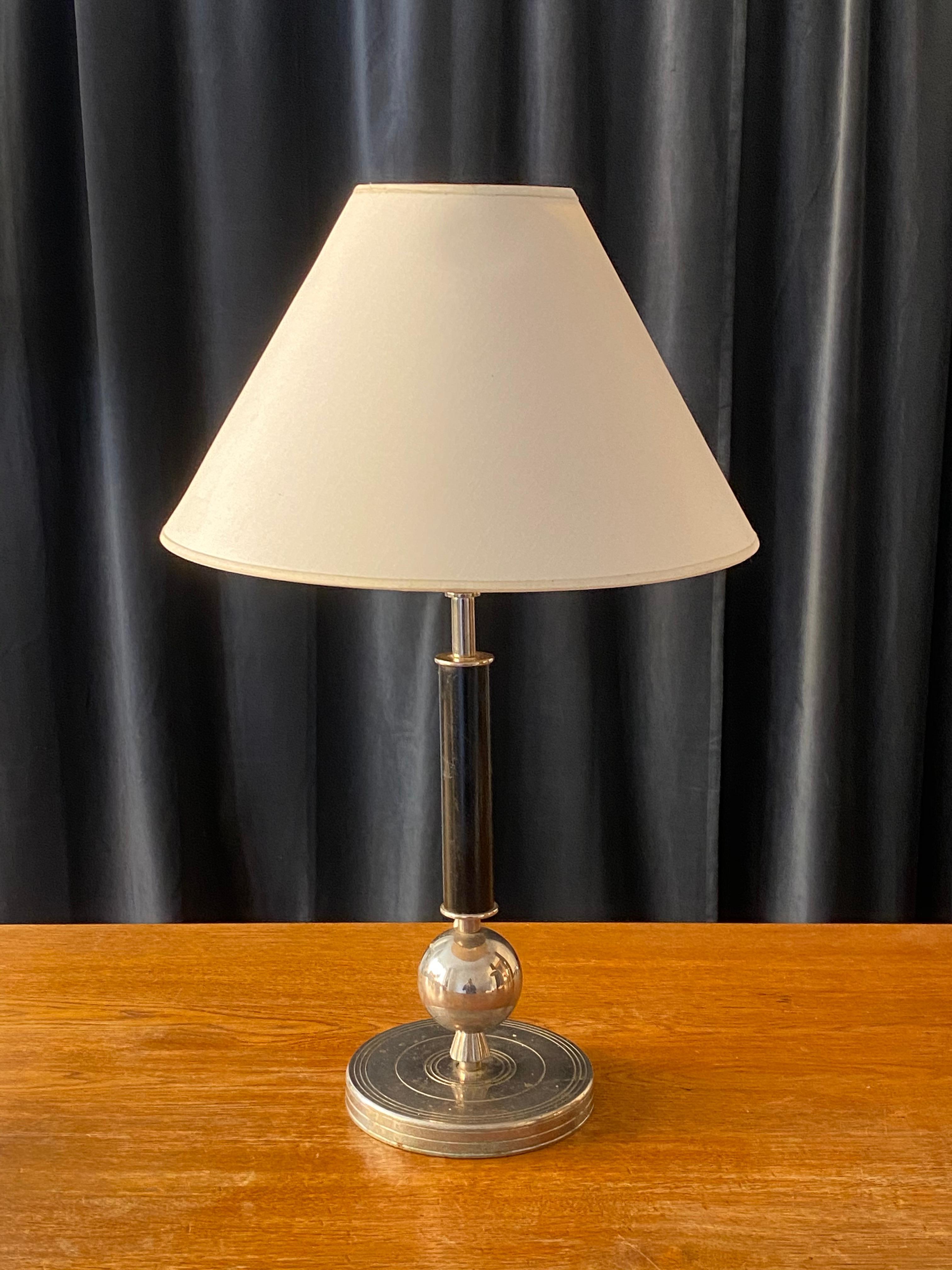 An elegant Art Deco / functionalist table lamp. By an unknown Swedish designer and producer. Base in stainless steel and original black-painted lacquer. The screen is not included.