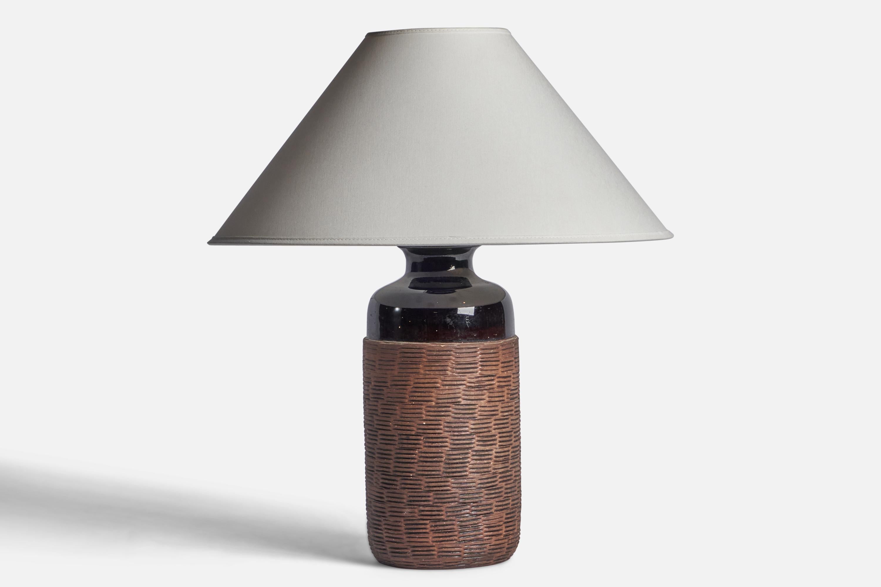 A black and brown-glazed incised stoneware table lamp designed and produced in Sweden, 1960s.

Dimensions of Lamp (inches): 14” H x 5.25” Diameter
Dimensions of Shade (inches): 4.5” Top Diameter x 16” Bottom Diameter x 7.25” H
Dimensions of Lamp