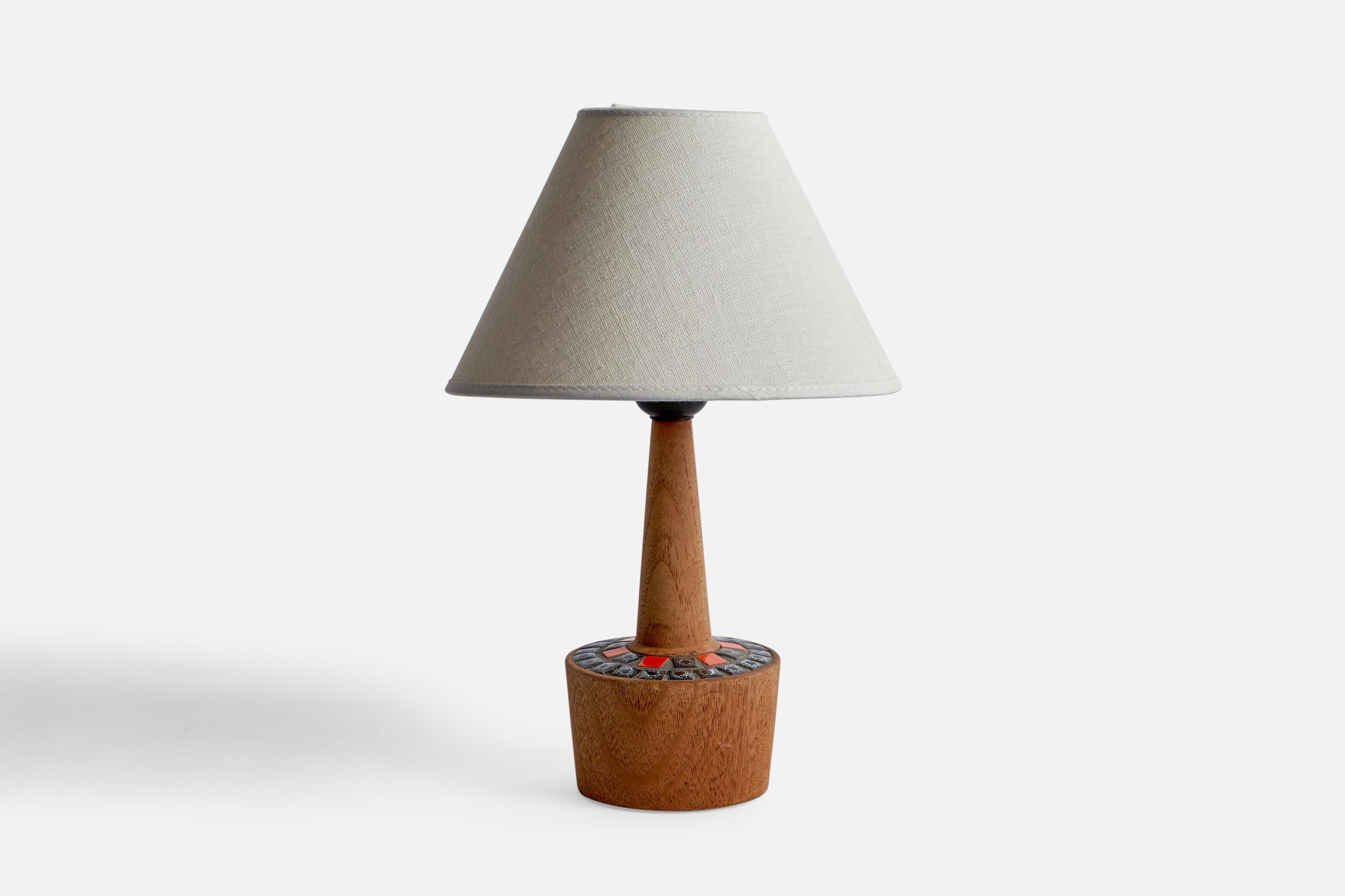 A teak and red and blue ceramic tile table lamp designed and produced in Sweden, 1950s.

Dimensions of Lamp (inches): 8.95” H x 3.84” Diameter
Dimensions of Shade (inches): 3” Top Diameter x 8” Bottom Diameter x 5” H
Dimensions of Lamp with Shade