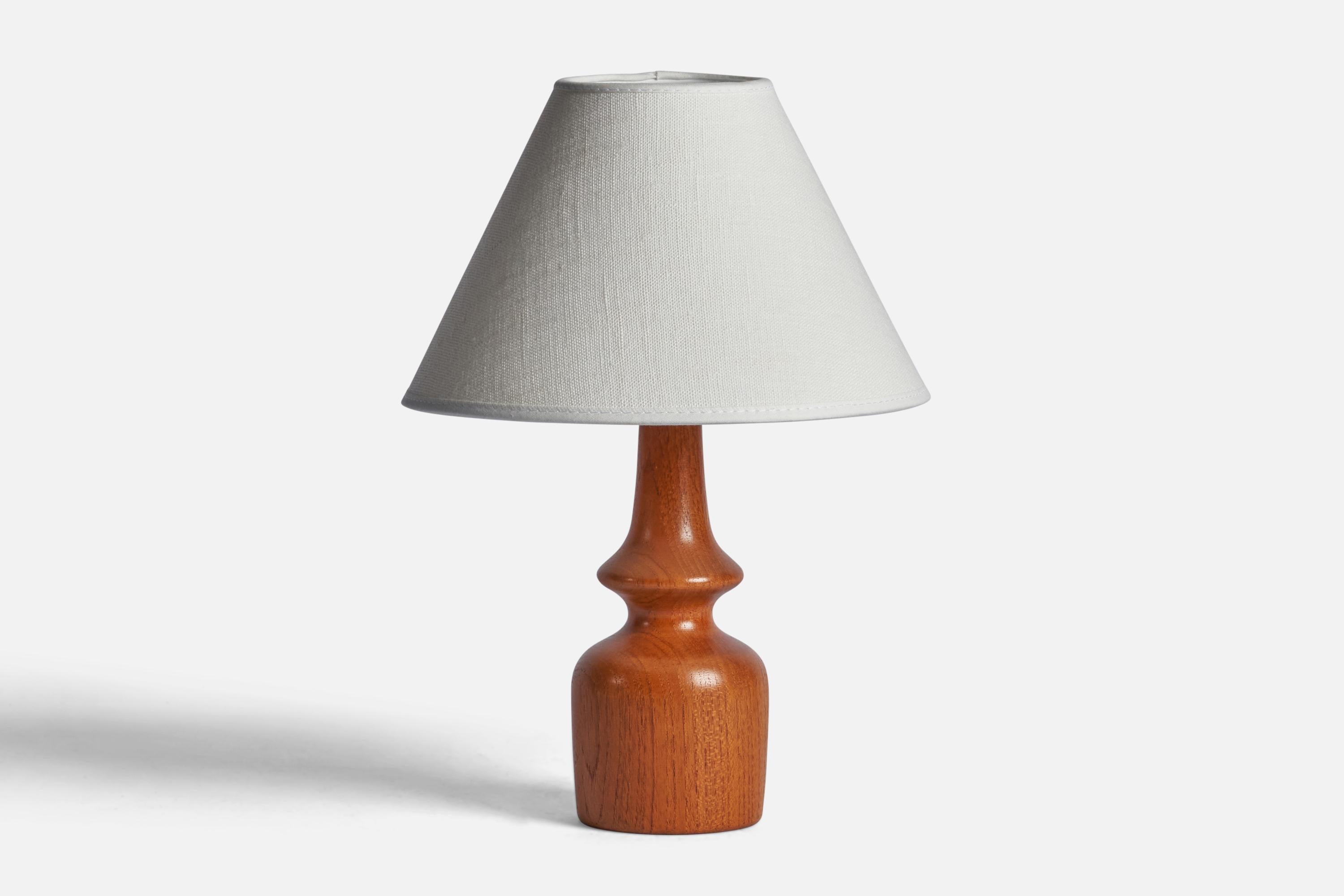 A teak table lamp designed and produced in Sweden, 1950s.

Dimensions of Lamp (inches): 8.75” H x 2.75” Diameter
Dimensions of Shade (inches): 3” Top Diameter x 8” Bottom Diameter x 5” H 
Dimensions of Lamp with Shade (inches): 11.15” H x 8”