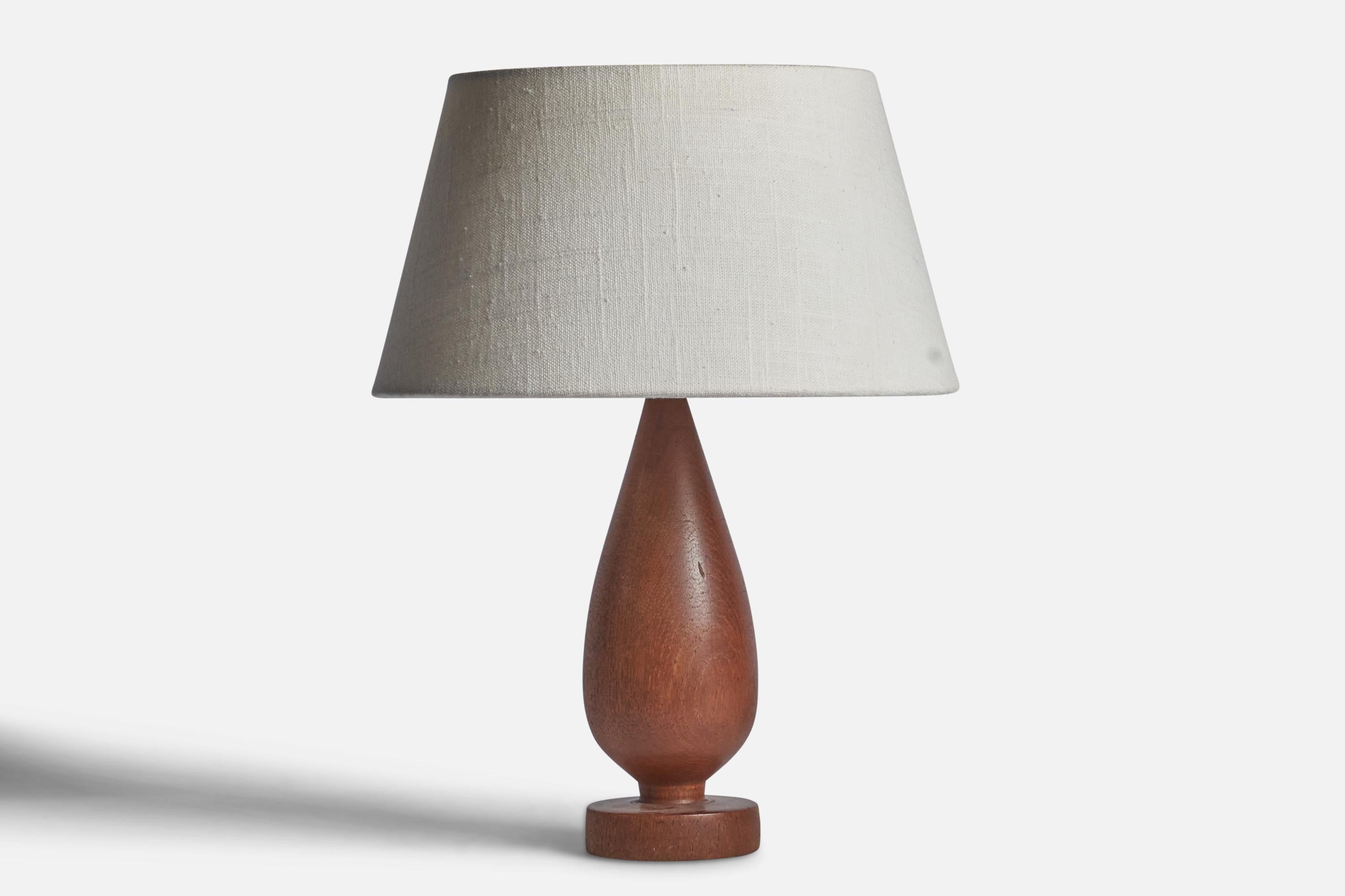 A turned teak table lamp designed and produced in Sweden, c. 1950s.

Dimensions of Lamp (inches): 10.25” H x 3” Diameter
Dimensions of Shade (inches): 7” Top Diameter x 10” Bottom Diameter x 5.5” H 
Dimensions of Lamp with Shade (inches): 13.25” H x