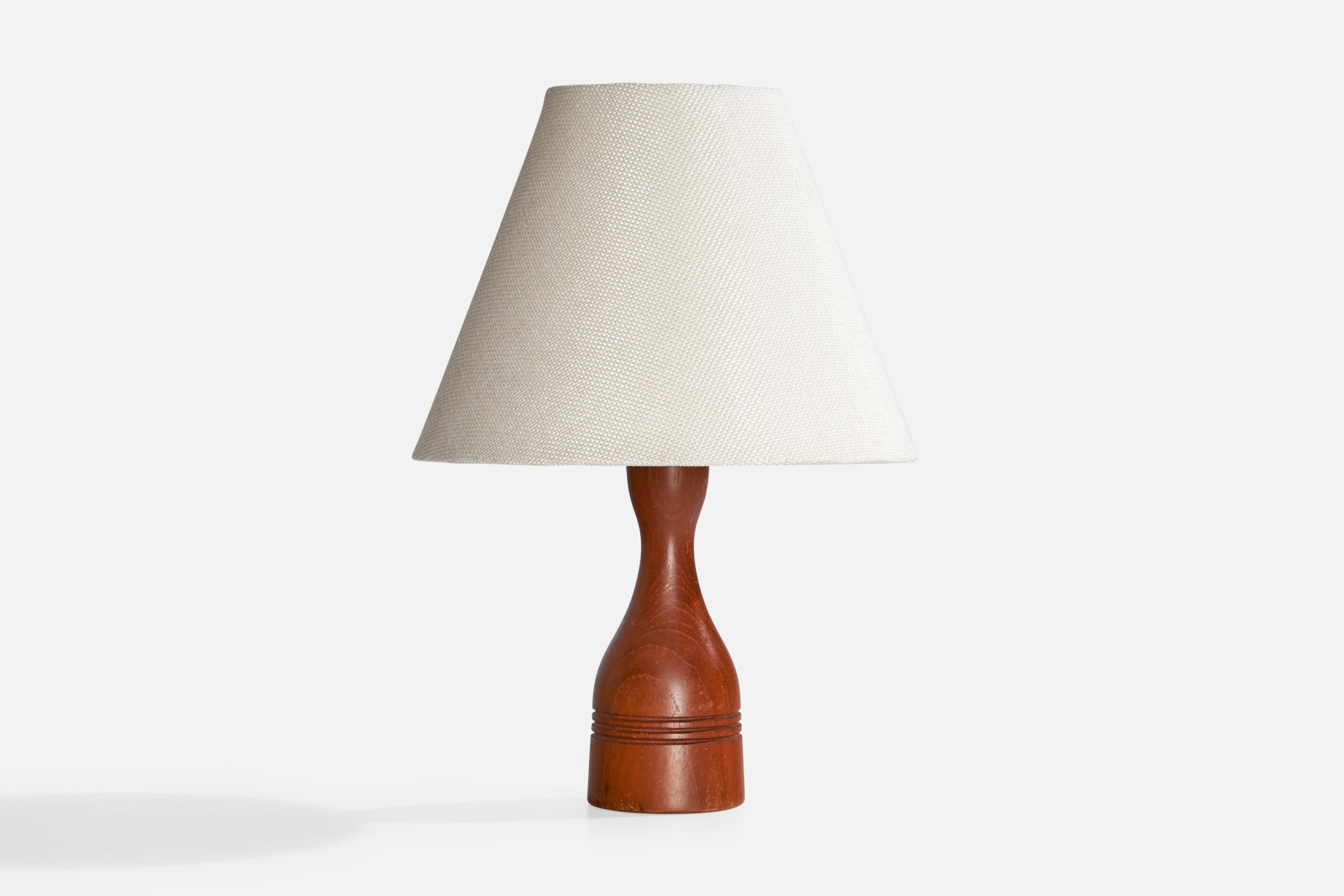 A teak table lamp designed and produced in Sweden, c. 1960s.

Dimensions of Lamp (inches):  8“ H x 2.5” diameterDimensions of Shade (inches):  3.75“ Top Diameter x  8“ Bottom Diameter x  6.25“ H

Dimensions of Lamp with Shade (inches): 11.25” H x 8“