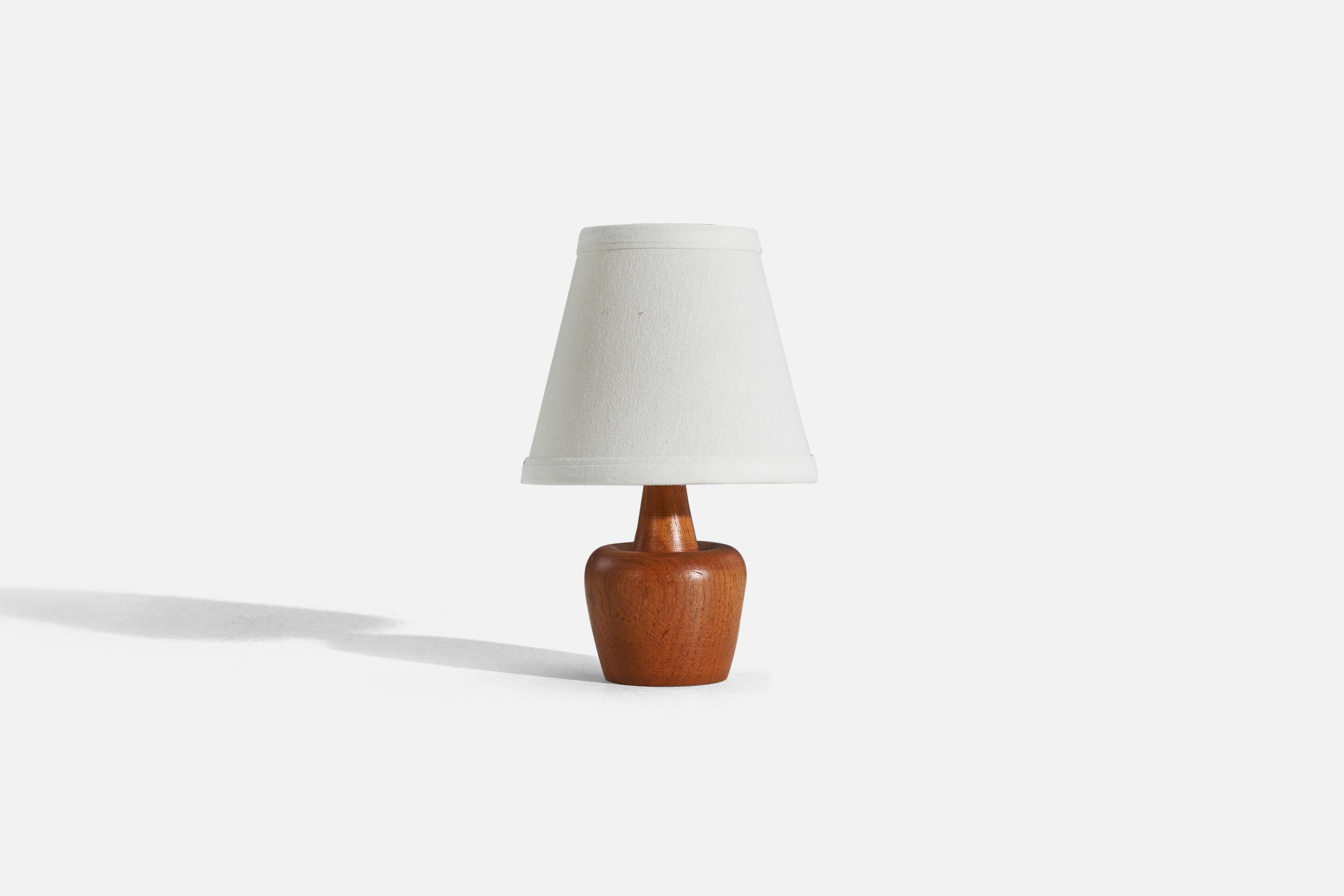 A teak table lamp designed and produced in Sweden, c. 1950s. 

Sold without lampshade. 
Dimensions of Lamp (inches) : 5.8125 x 2.9375 x 2.9375 (H x W x D)
Dimensions of Shade (inches) : 3 x 5 x 4.5 (T x B x H)
Dimension of Lamp with Shade