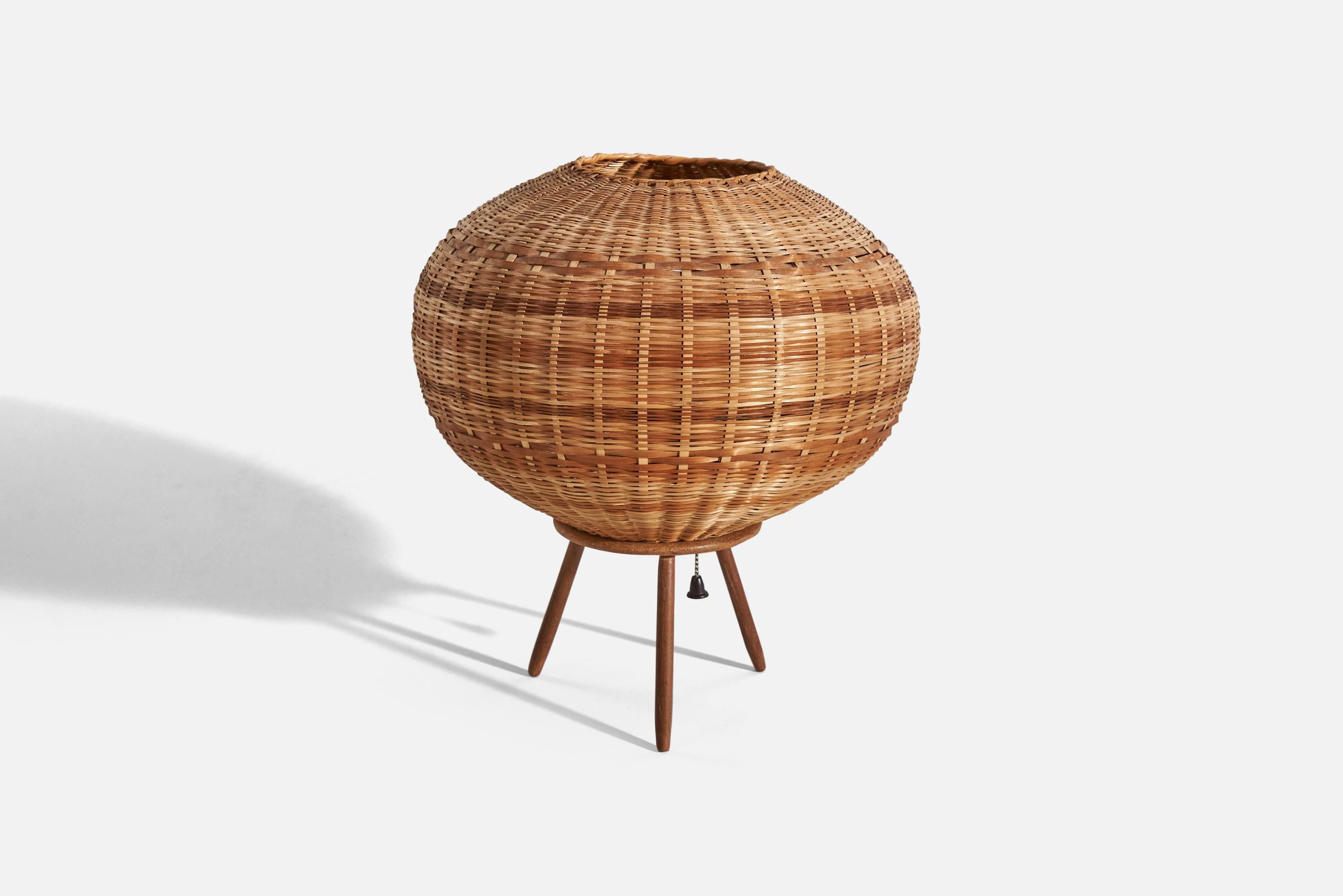 A wicker and teak table lamp designed and produced in Sweden, c. 1950s.

