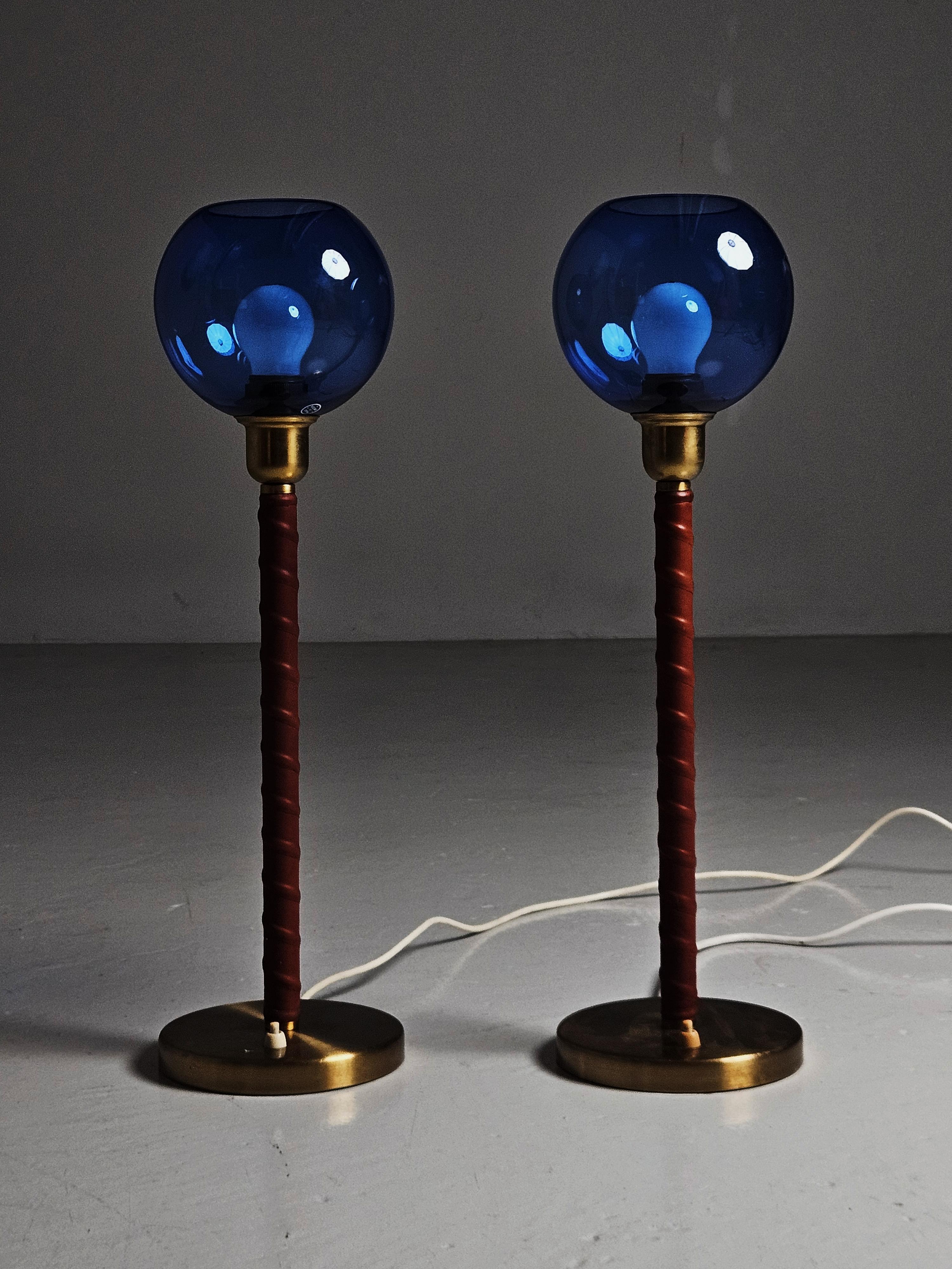 Beautiful pair of table lamps model 'E1251' by unknown designer. Produced by ASEA, Sweden, during the 1950s. 

Made in brass, neck wrapped in brown leather and blue glass. 