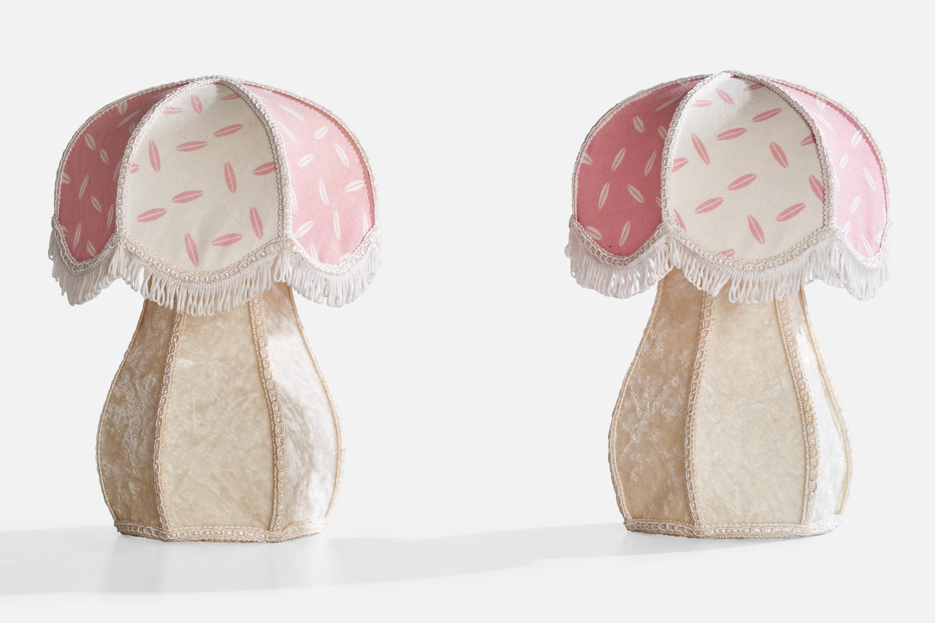 A pair of pink and off-white fabric over metal table lamps designed and produced in Sweden, c. 1970s.

Dimensions of Lamp with Shade (inches): 9.25“ H x 7“ Diameter

Bulb Specifications: E-14

Number of Sockets (per fixture): 1

Sold with