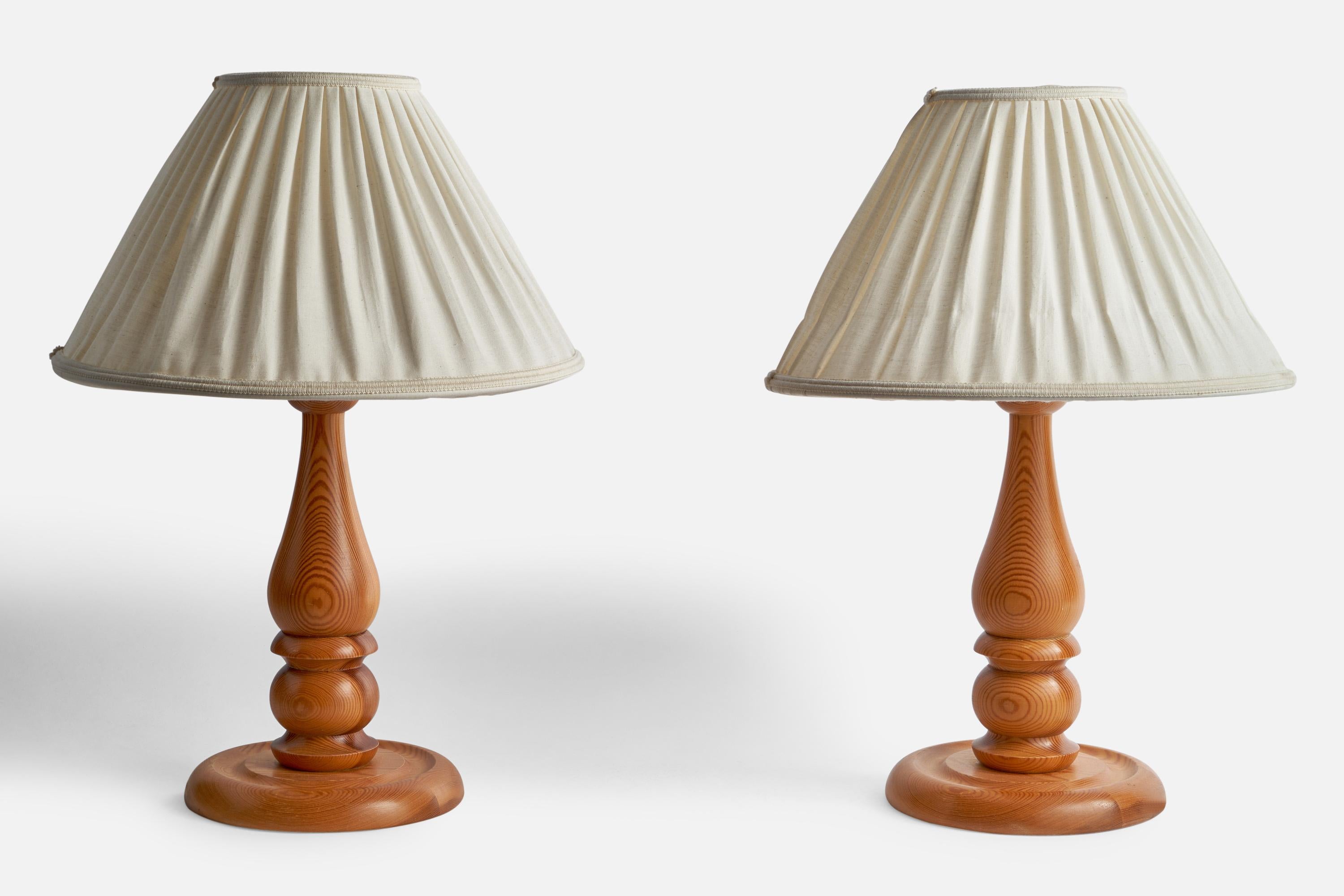 A pair of pine and off-white fabric table lamps designed and produced in Sweden, 1970s.

Overall Dimensions (inches): 20.6” H x 14.5” Diameter
Bulb Specifications: E-26 Bulbs
Number of Sockets: 2
All lighting will be converted for US usage. We is