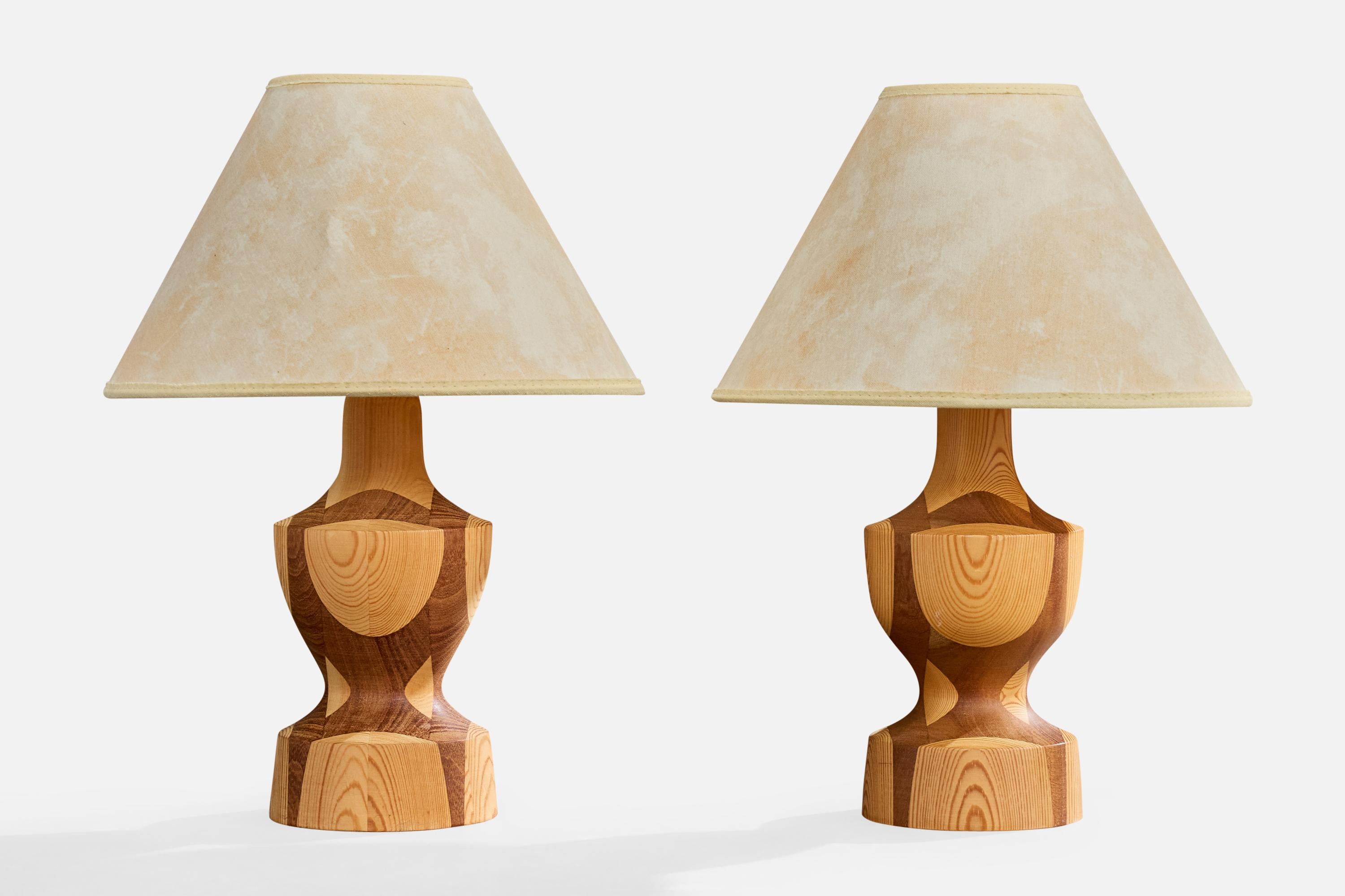 A pair of stack-laminated pine, teak, and beige parchment paper table lamps designed and produced in Sweden, c. 1970s.

Overall Dimensions (inches): 13.5