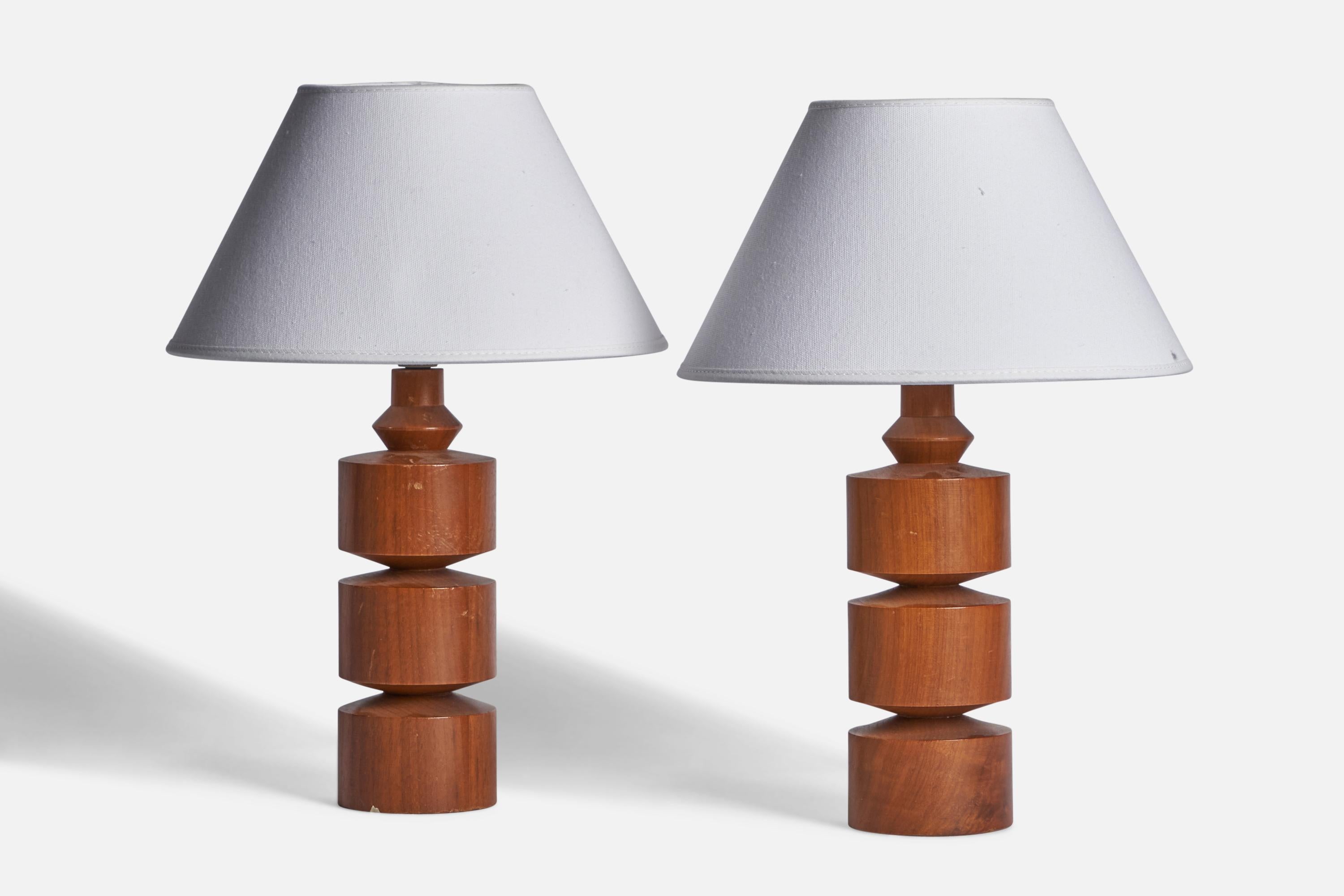 
A pair of teak table lamps designed and produced in Sweden, c. 1950s.
Dimensions of Lamp (inches): 11” H x 3.25” Diameter
Dimensions of Shade (inches): 4.5” Top Diameter x 10” Bottom Diameter x 5.5” H 
Dimensions of Lamp with Shade (inches): 14.5”