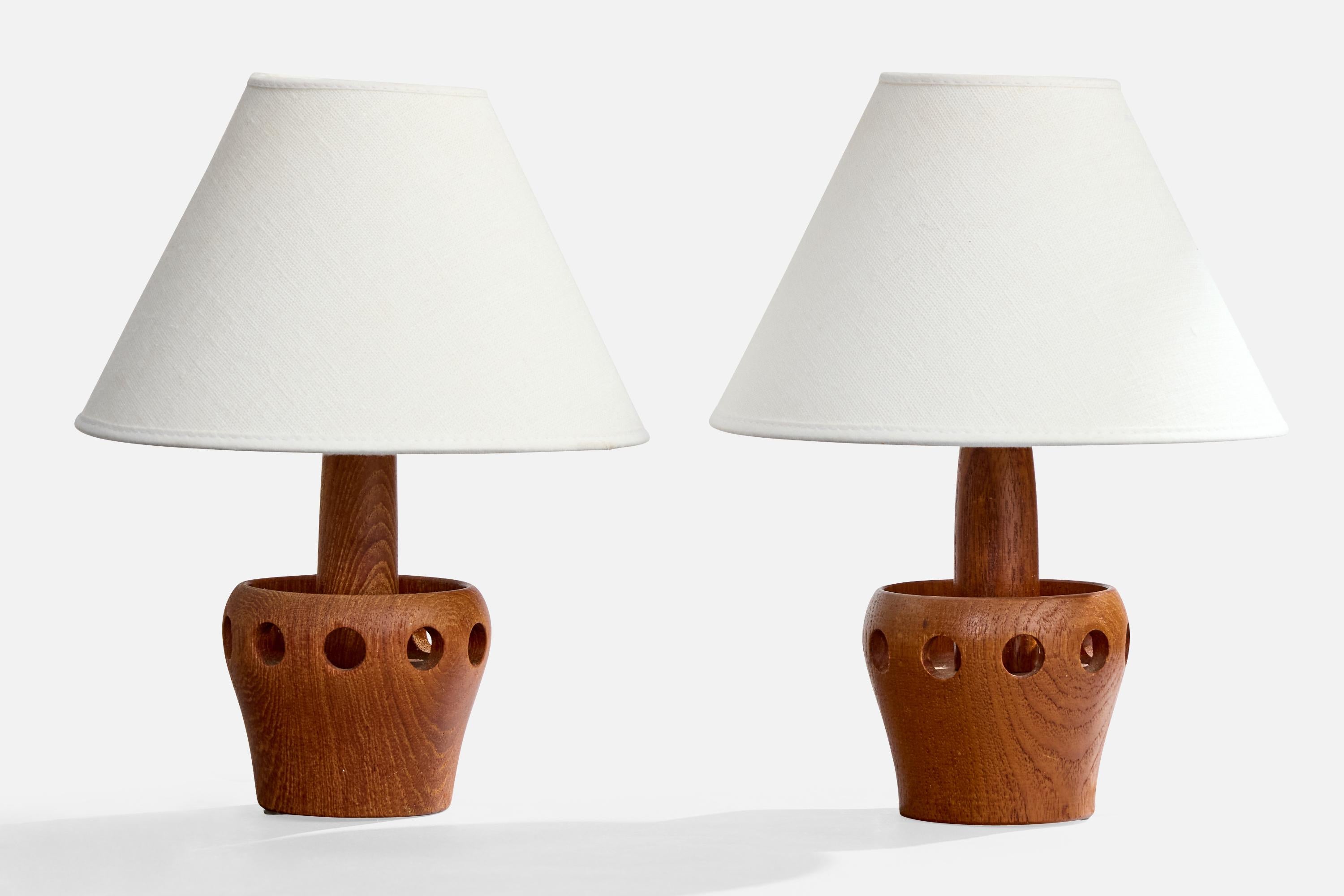 A pair of teak table lamps designed and produced in Sweden, c. 1950s.

Dimensions of Lamp (inches): 7.5“ H x 3.8“ Diameter

Dimensions of Shade (inches): 3.25” Top Diameter x 8“ Bottom Diameter x 5.5” H

Dimensions of Lamp with Shade (inches): 10” H