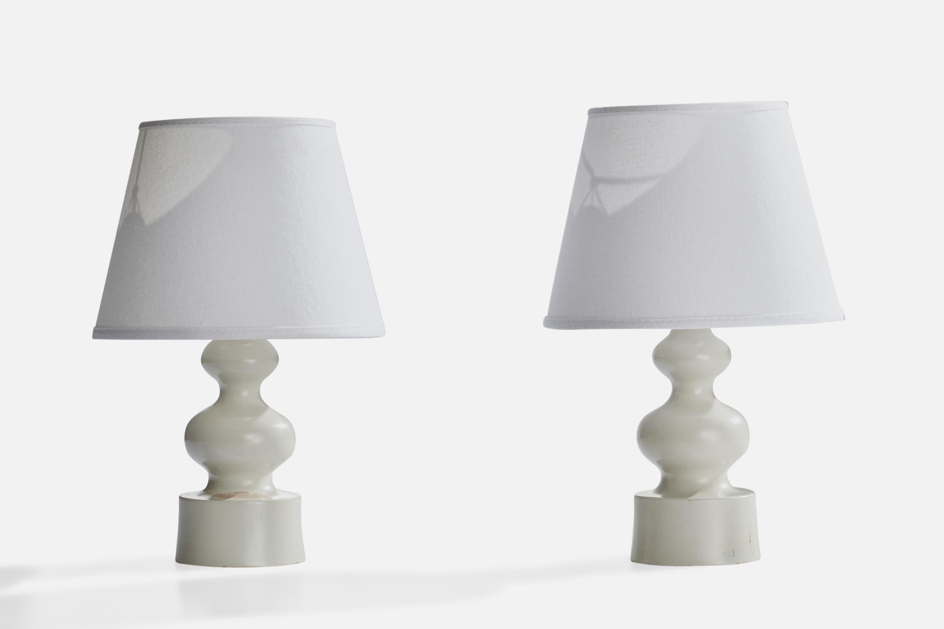 A pair of white-lacquered wood table lamps designed and produced in Sweden, c. 1970s.

Dimensions of Lamp (inches): 9” H x 3.75” Diameter
Dimensions of Shade (inches): 5” Top Diameter x 7.75” Bottom Diameter x 6” H
Dimensions of Lamp with Shade