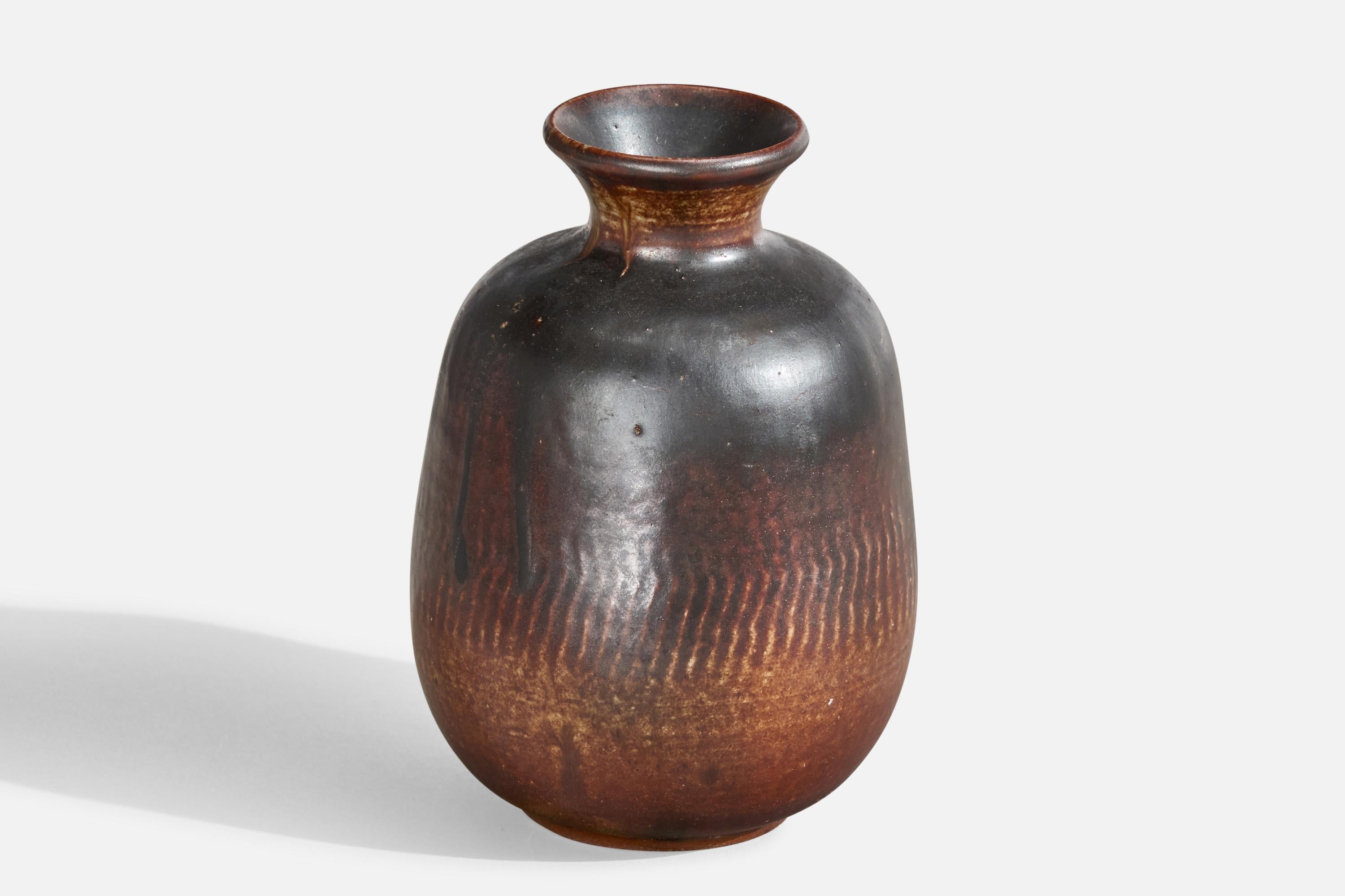 Un vaso in ceramica smaltata marrone e nera progettato e prodotto in Svezia, datato 1982.
