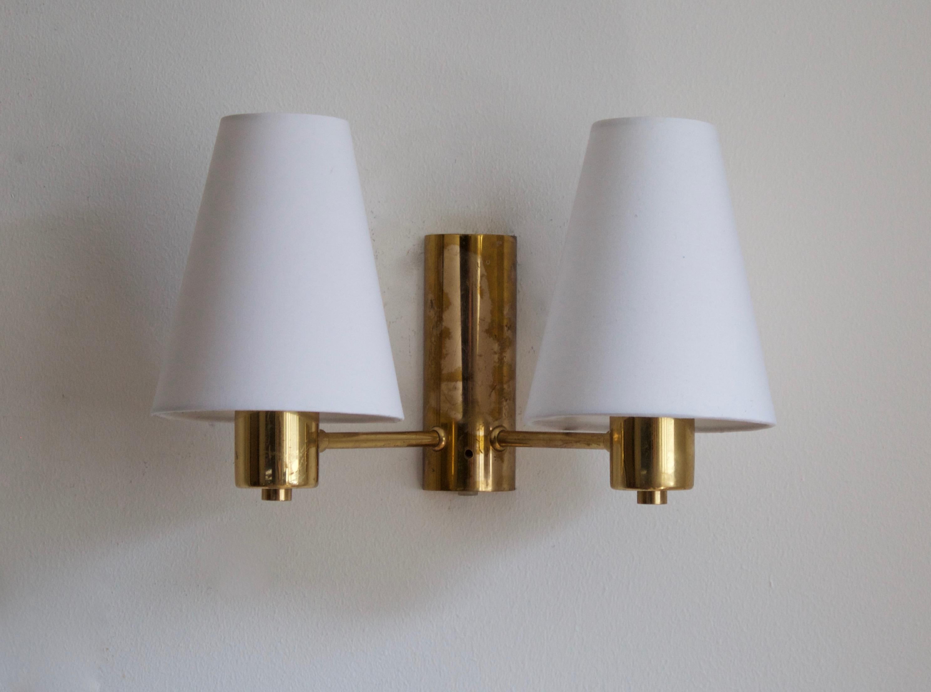 A two armed wall light. designed and produced in Sweden, 1950s. Brand new lampshades.

Stated dimensions with lampshade attached. Dimensions variable.