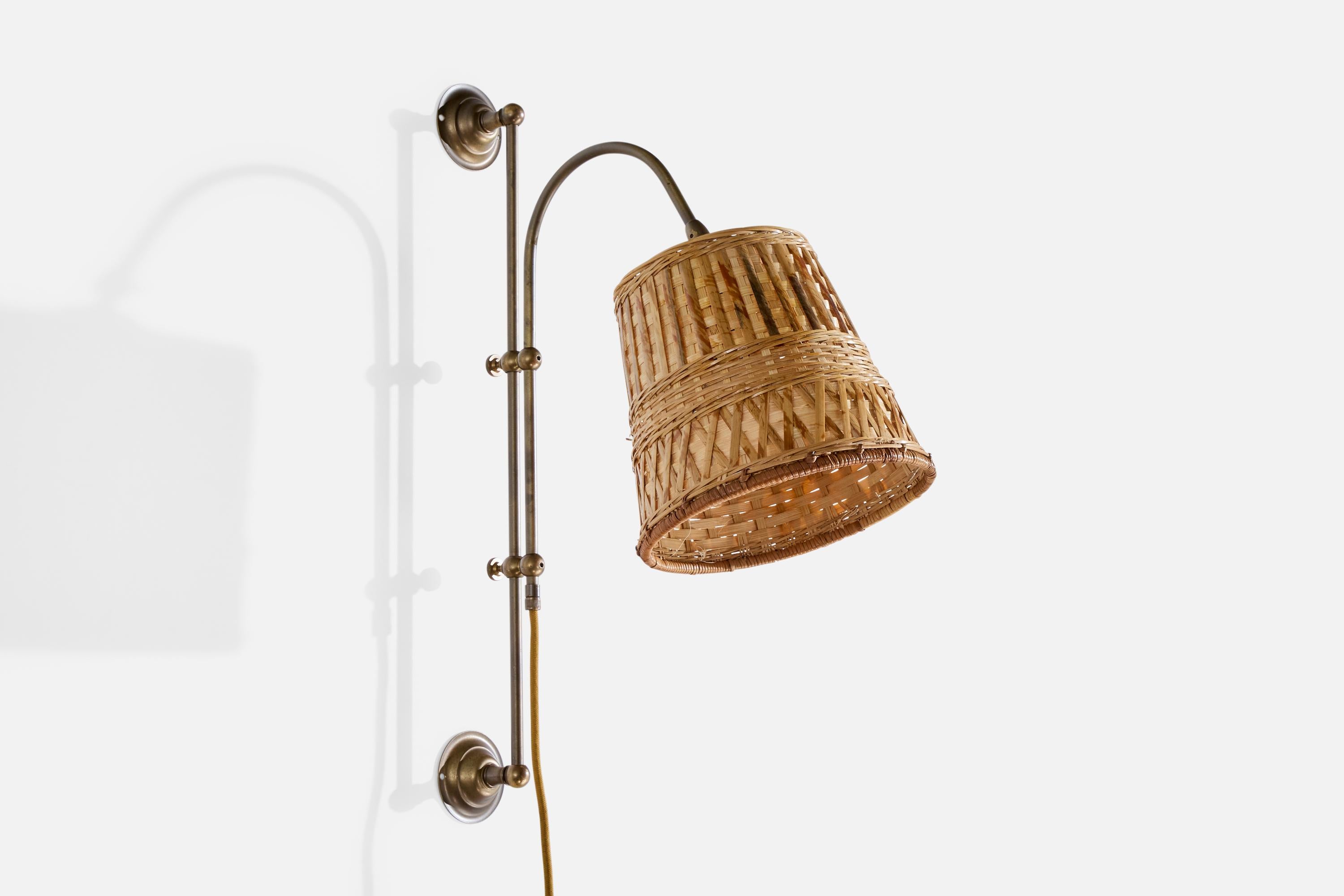 Lampada da parete regolabile in ottone e rattan progettata e prodotta in Svezia negli anni '60.

Dimensioni complessive (pollici): 22,75 