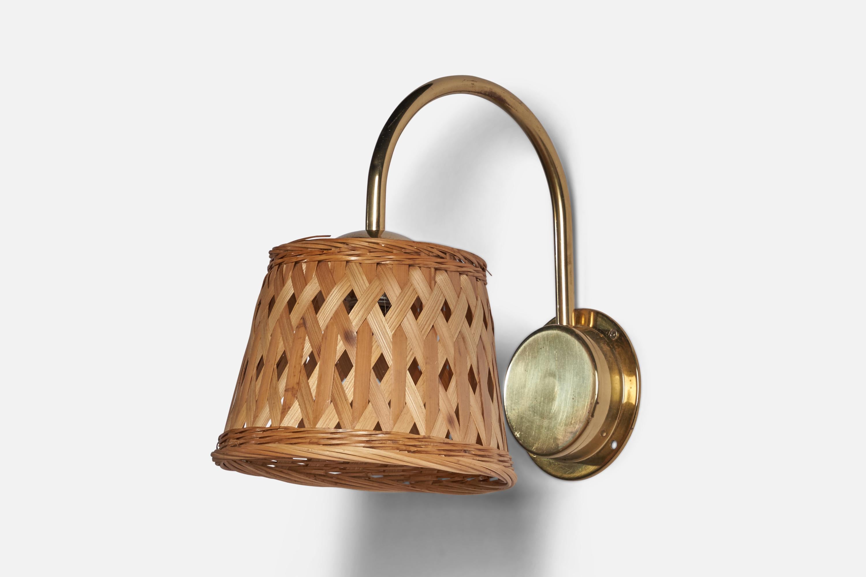 A brass and rattan wall light designed and produced in Sweden, c. 1970s.

Overall Dimensions (inches): 10” H x 7.25” W x 10” D
Back Plate Dimensions (inches): 4.25” Diameter
Bulb Specifications: E-14 Bulb
Number of Sockets: 1
All lighting will be