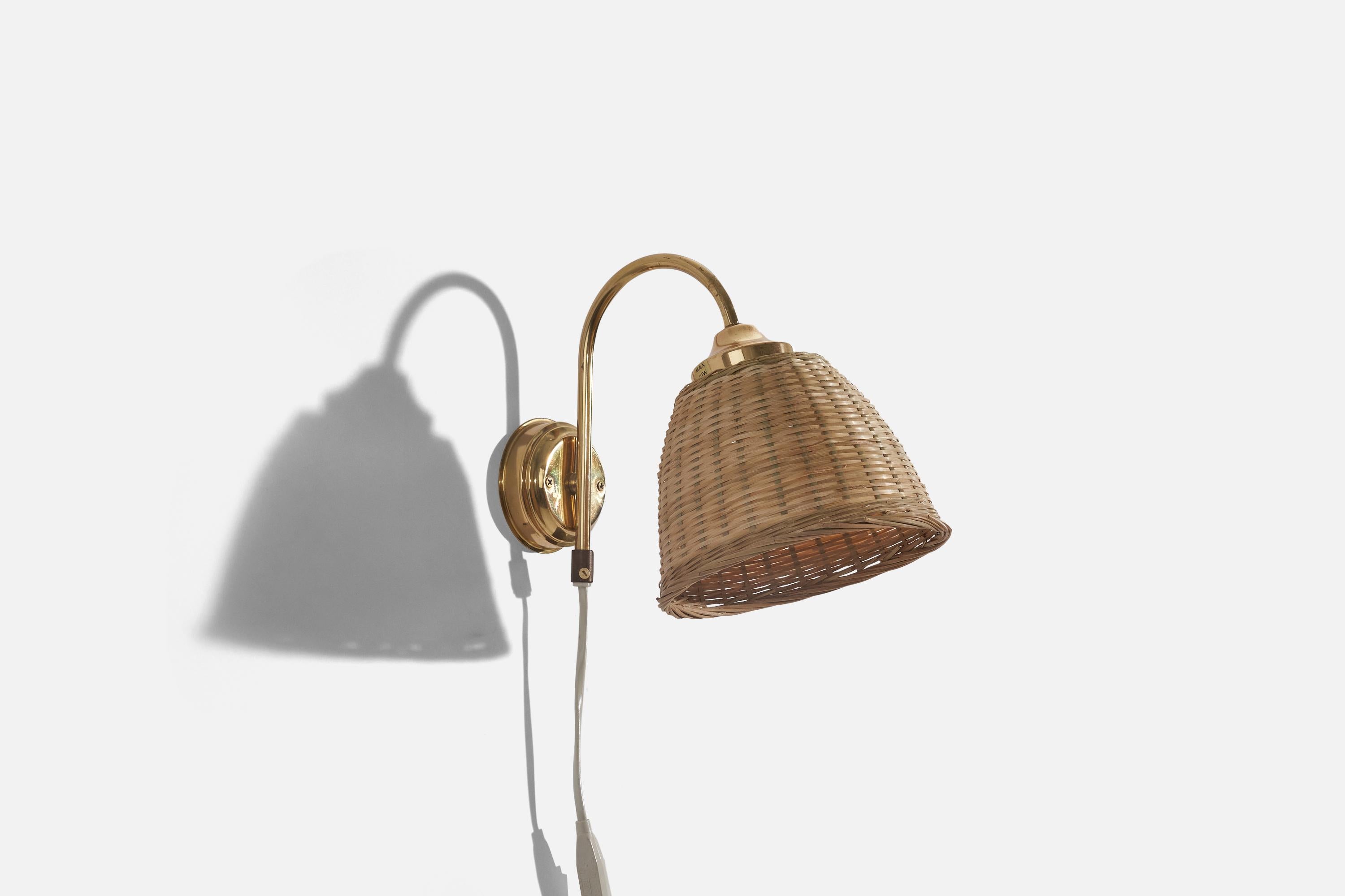 A brass and rattan wall light designed and produced in Sweden, c. 1970s. 

Sold with lampshade. 
Stated dimensions refer to the Lamp with Shade. 
Dimensions of back plate (inches) : 3.31 x 3.31 x 1 (H x W x D).