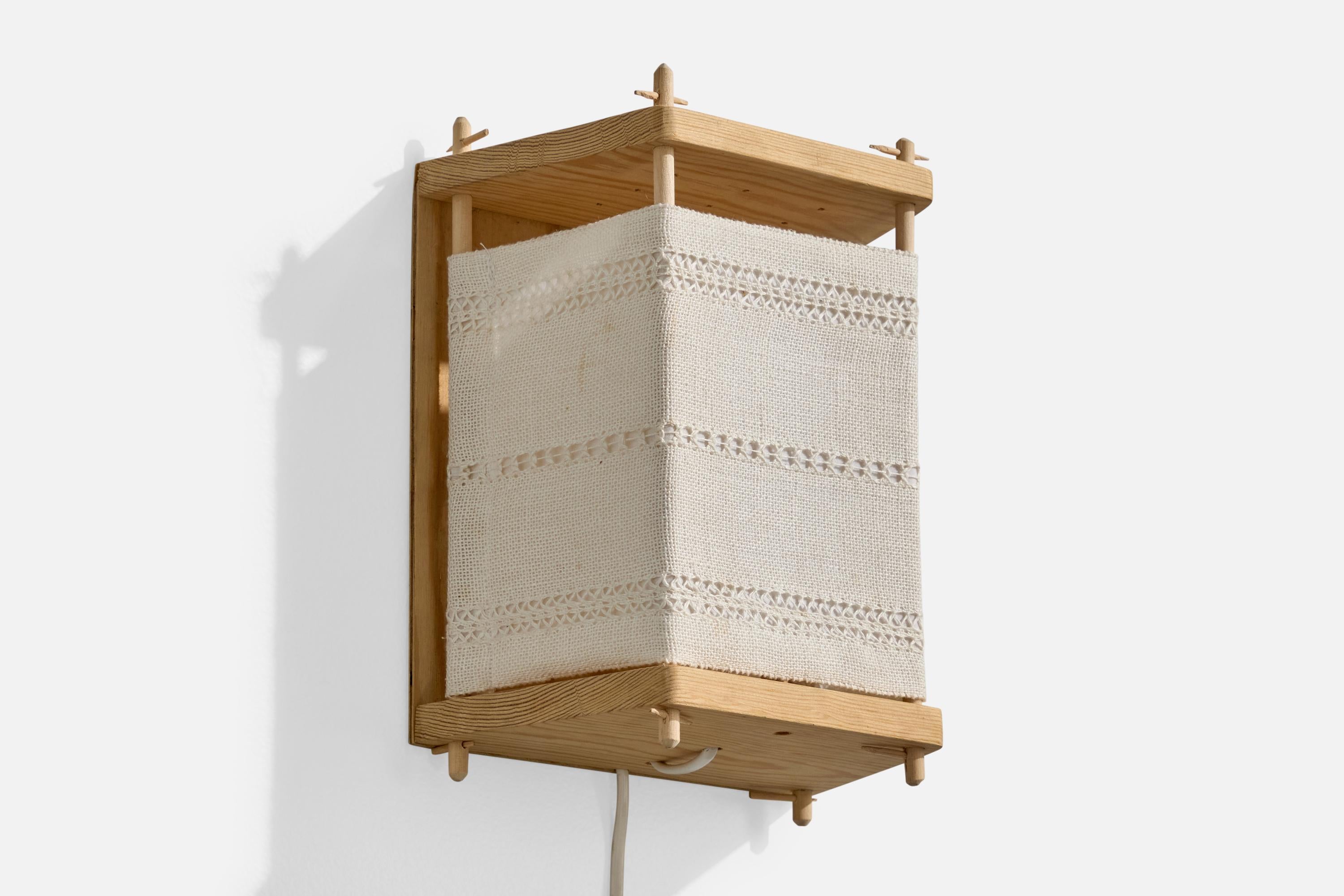 Wandleuchte aus Kiefer und cremefarbenem Stickereistoff, entworfen und hergestellt in Schweden, ca. 1970er Jahre.

Gesamtabmessungen (Zoll): 10,5
