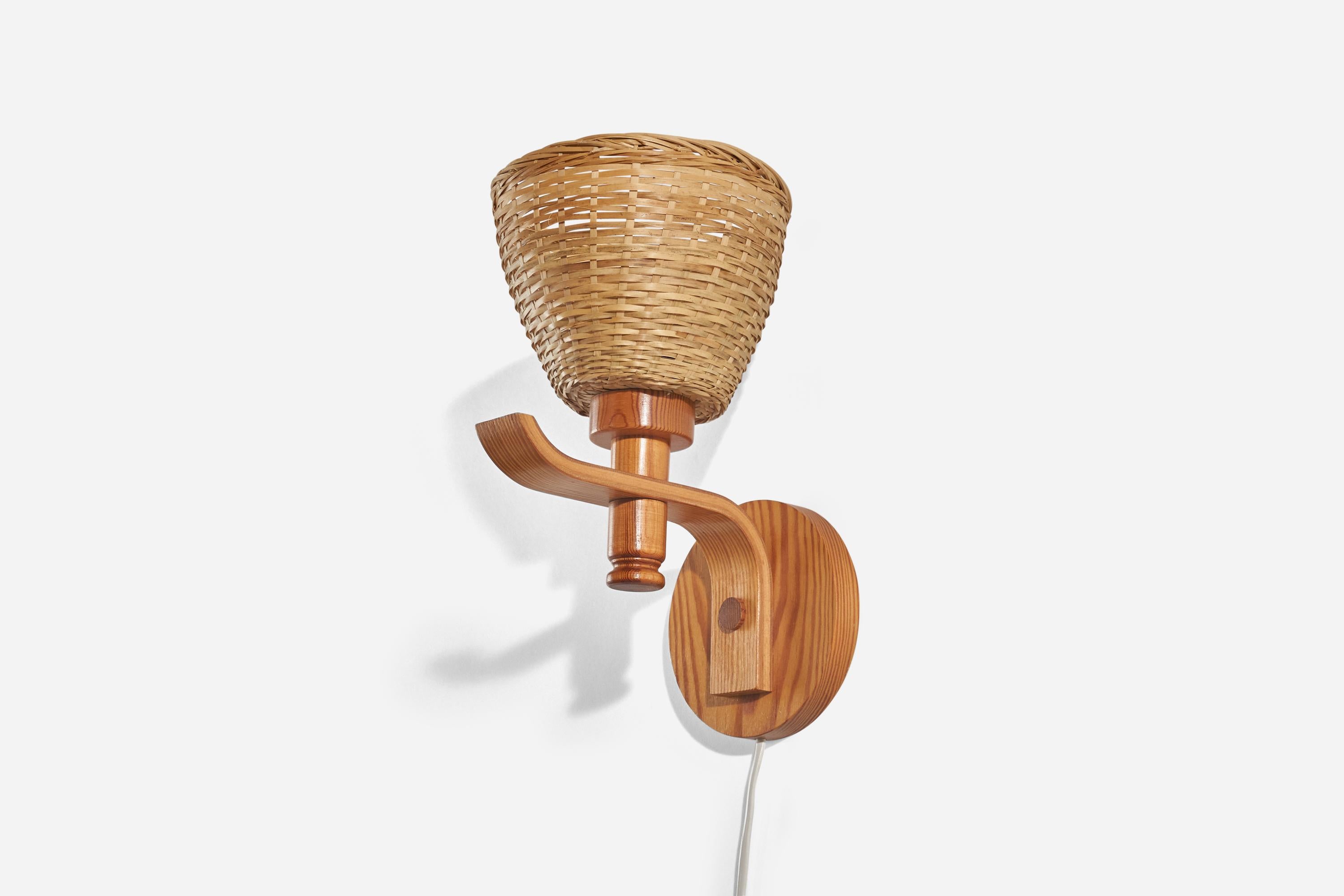 A pine and rattan wall light designed and produced in Sweden, 1970s.

Sold with Lampshade(s). Dimensions stated are of Sconce with Shade(s).

Dimensions of Back Plate (inches) : 5.49 x 5.49 x 0.78 (Height x Width x Depth).

Socket takes