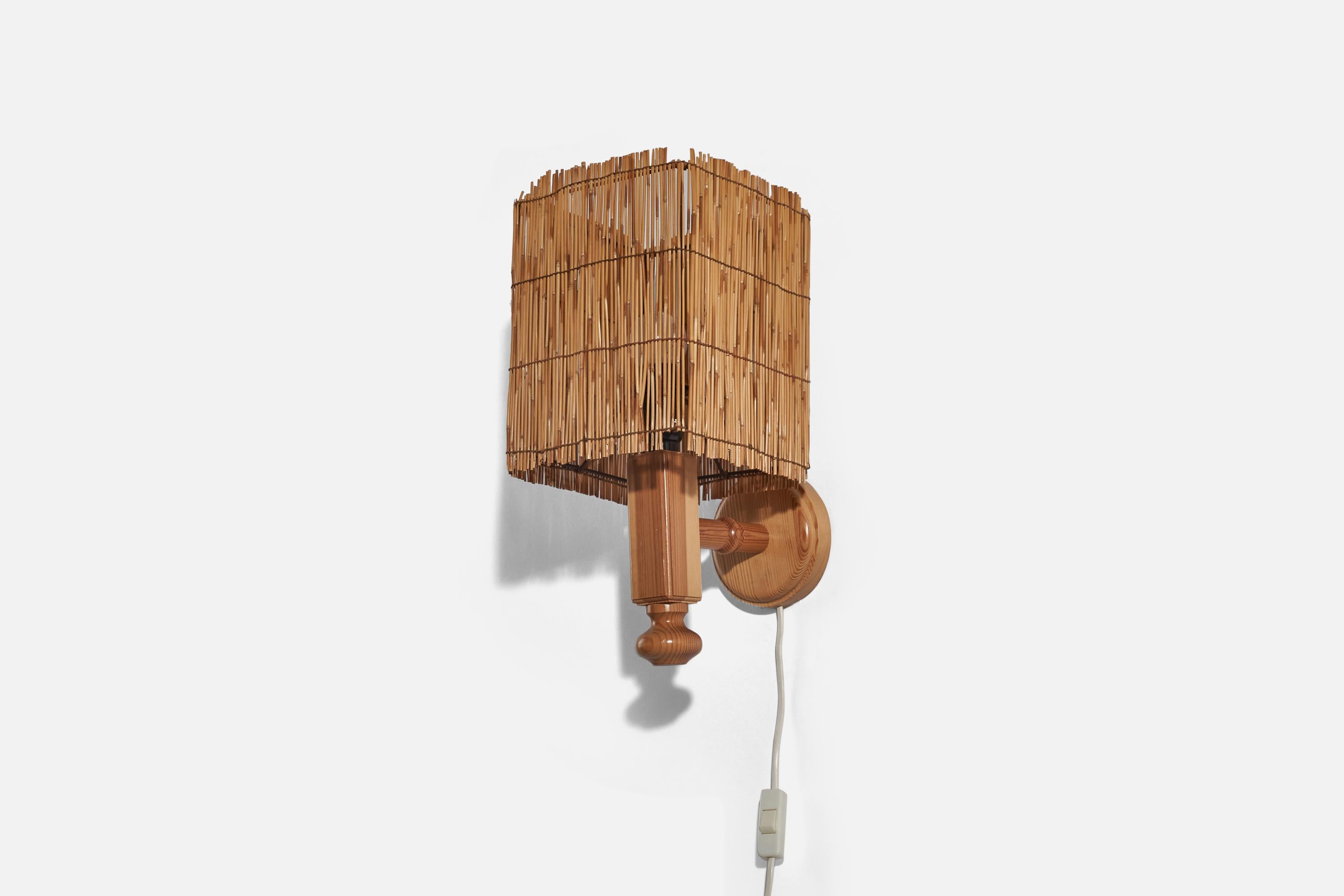 A pine and rattan wall light designed in Sweden, c. 1970s. 

Dimensions of back plate (inches) : 4.5 x 4.5 x 1 (H x W x D).

Lampshade included.