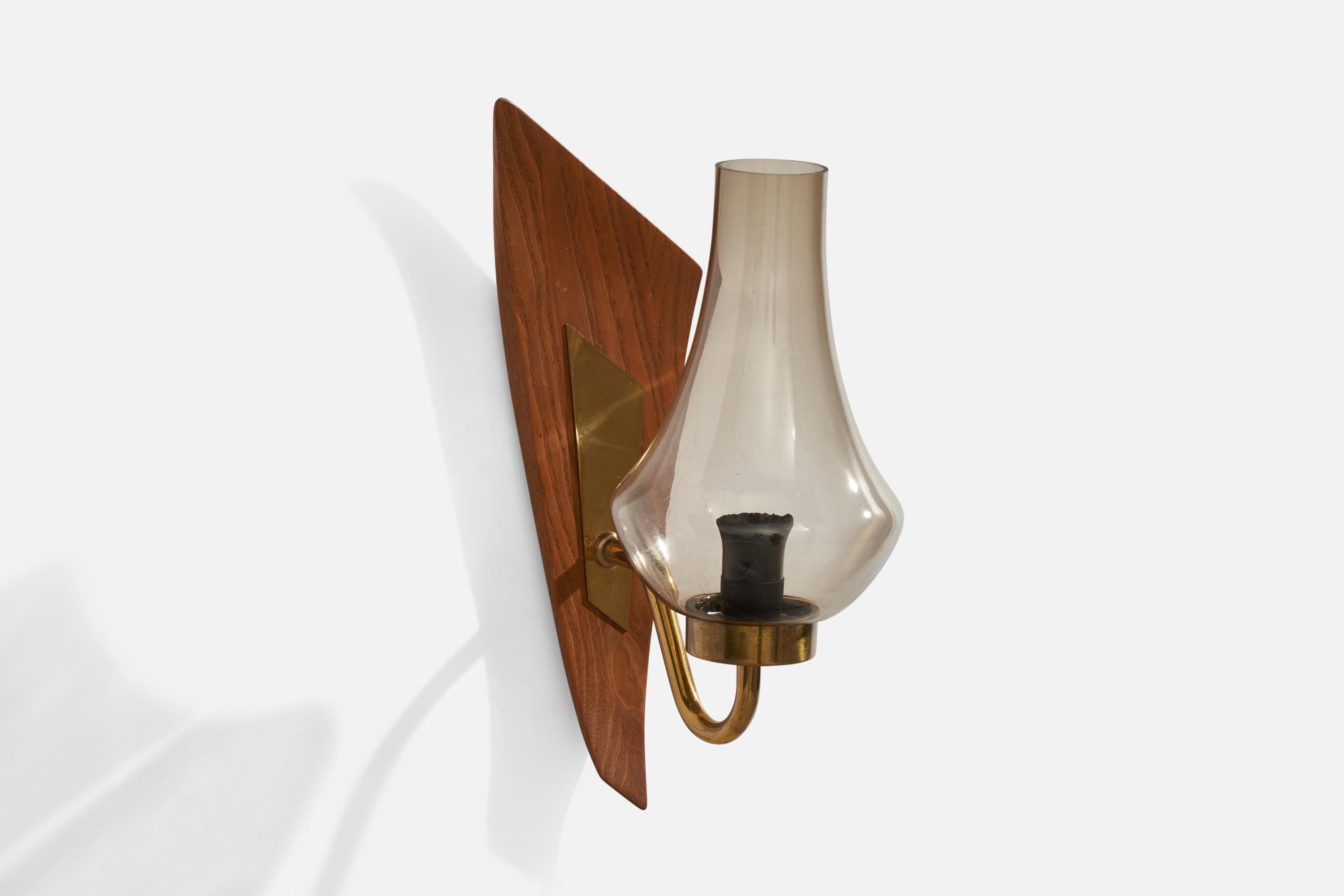 A brass, teak and smoked glass wall light designed and produced in Sweden, 1950s.

Overall Dimensions (inches): 11.25” H x 3.75”  W x 6” D
Back Plate Dimensions (inches): n/a
Bulb Specifications: E-14 Bulb
Number of Sockets: 1
All lighting will be