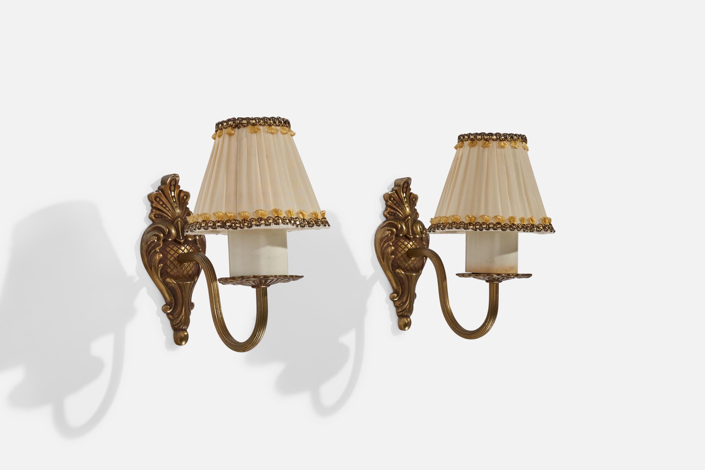 A pair of brass, bakelite and fabric wall lights designed and produced in Sweden, c. 1940s.

Overall Dimensions (inches): 8” H x 4.25” W x 8.25” D
Back Plate Dimensions (inches): N/A
Bulb Specifications: E-26 Bulb
Number of Sockets: 2
All lighting