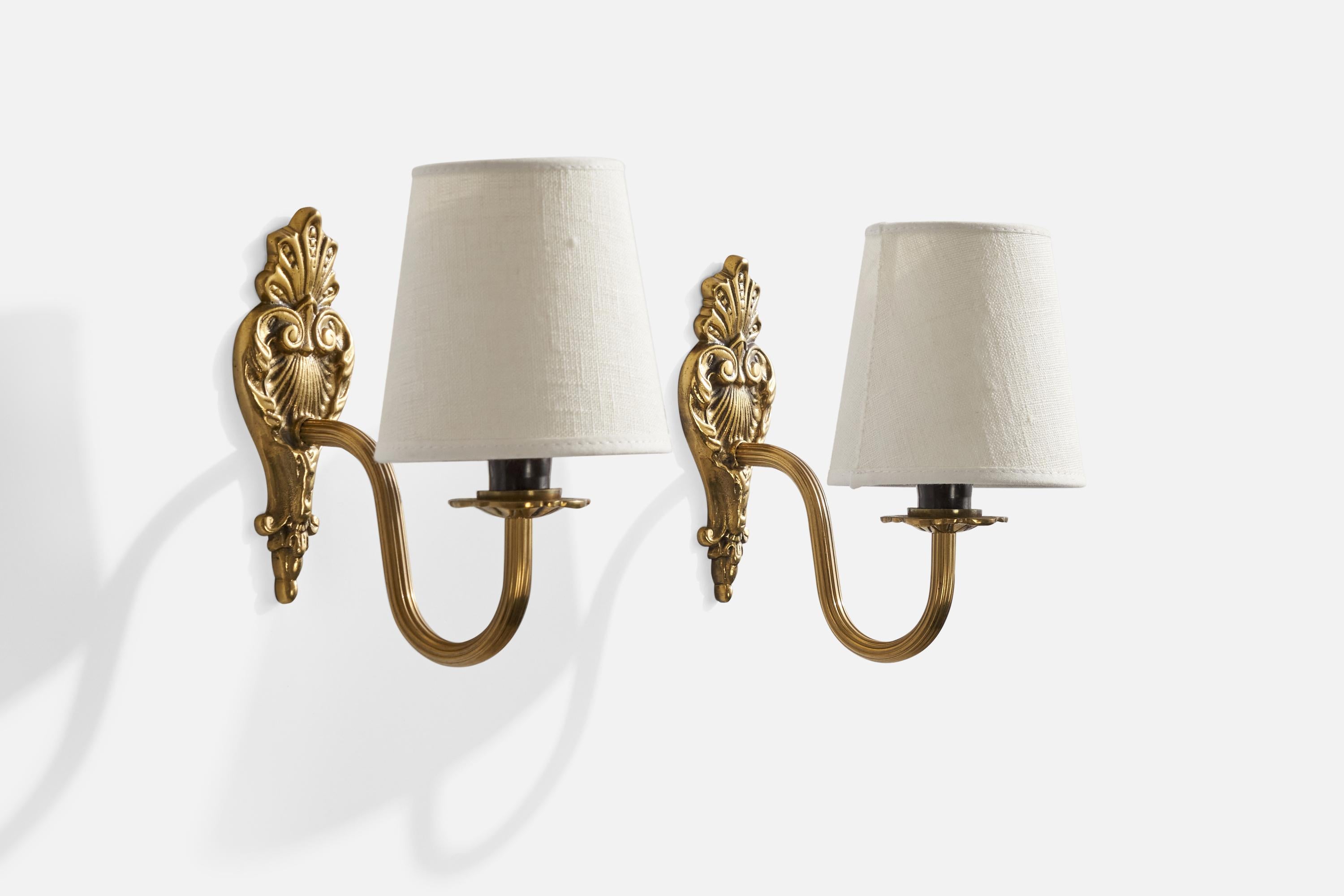 A pair of brass and white fabric wall lights designed and produced in sweden, 1940s.

Overall Dimensions (inches): 8.5” H x 5” W x 7.5” D
Back Plate Dimensions (inches): N/A
Bulb Specifications: E-14 Bulb
Number of Sockets: 2
All lighting will be