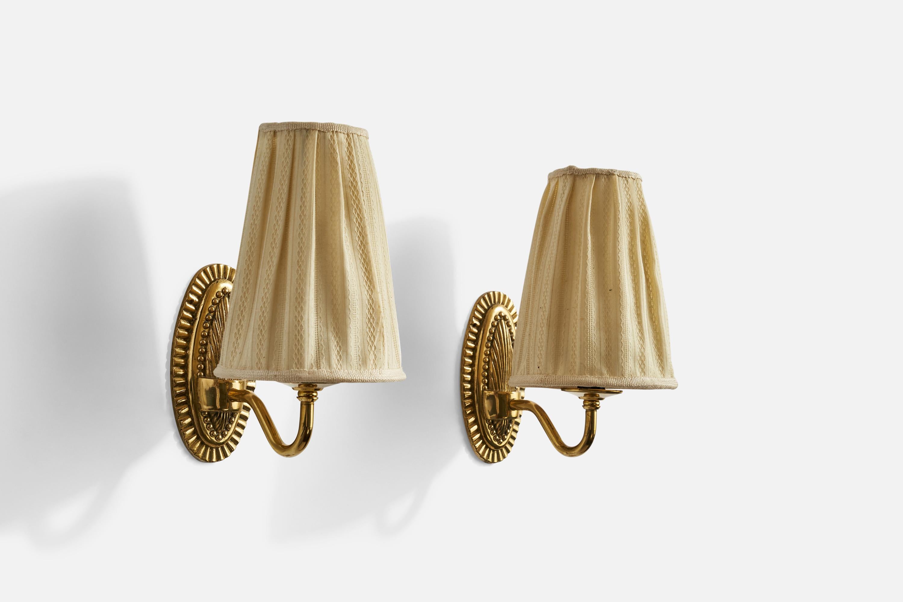 A pair of brass and beige fabric wall lights designed and produced in Sweden, c. 1950s.

Overall Dimensions (inches): 9”  H x 5”  W x 7.5” D
Back Plate Dimensions (inches): N/A
Bulb Specifications: E-12 Bulb
Number of Sockets: 2
All lighting will be