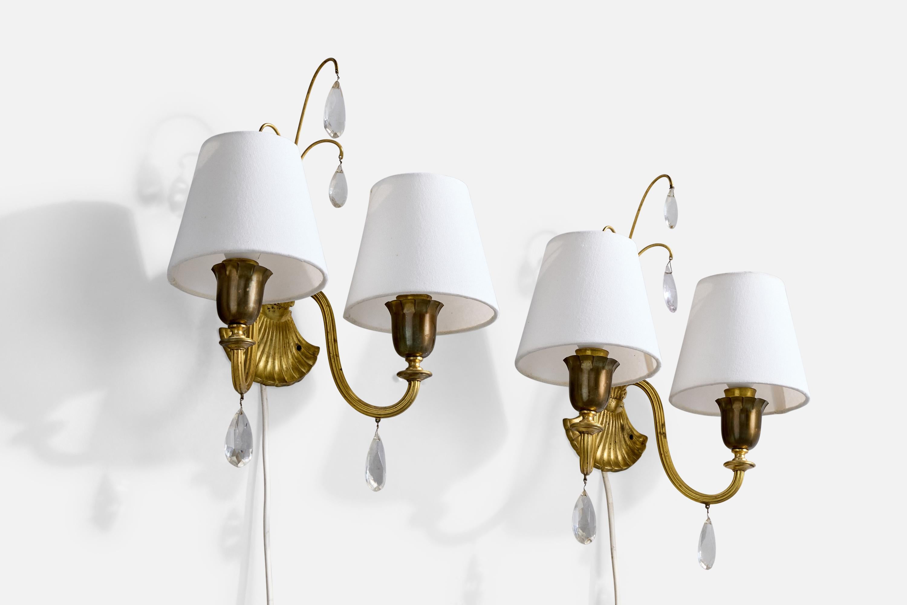A pair of brass, glass and white fabric wall lights likely designed and produced in Sweden, c. 1940s.

Overall Dimensions (Inches): 14.25” H x 11.5” W x 6.5“ D

Back Plate Dimensions (Inches): 2.625” H x 3.875“ W x .25” D

Bulb Specifications: