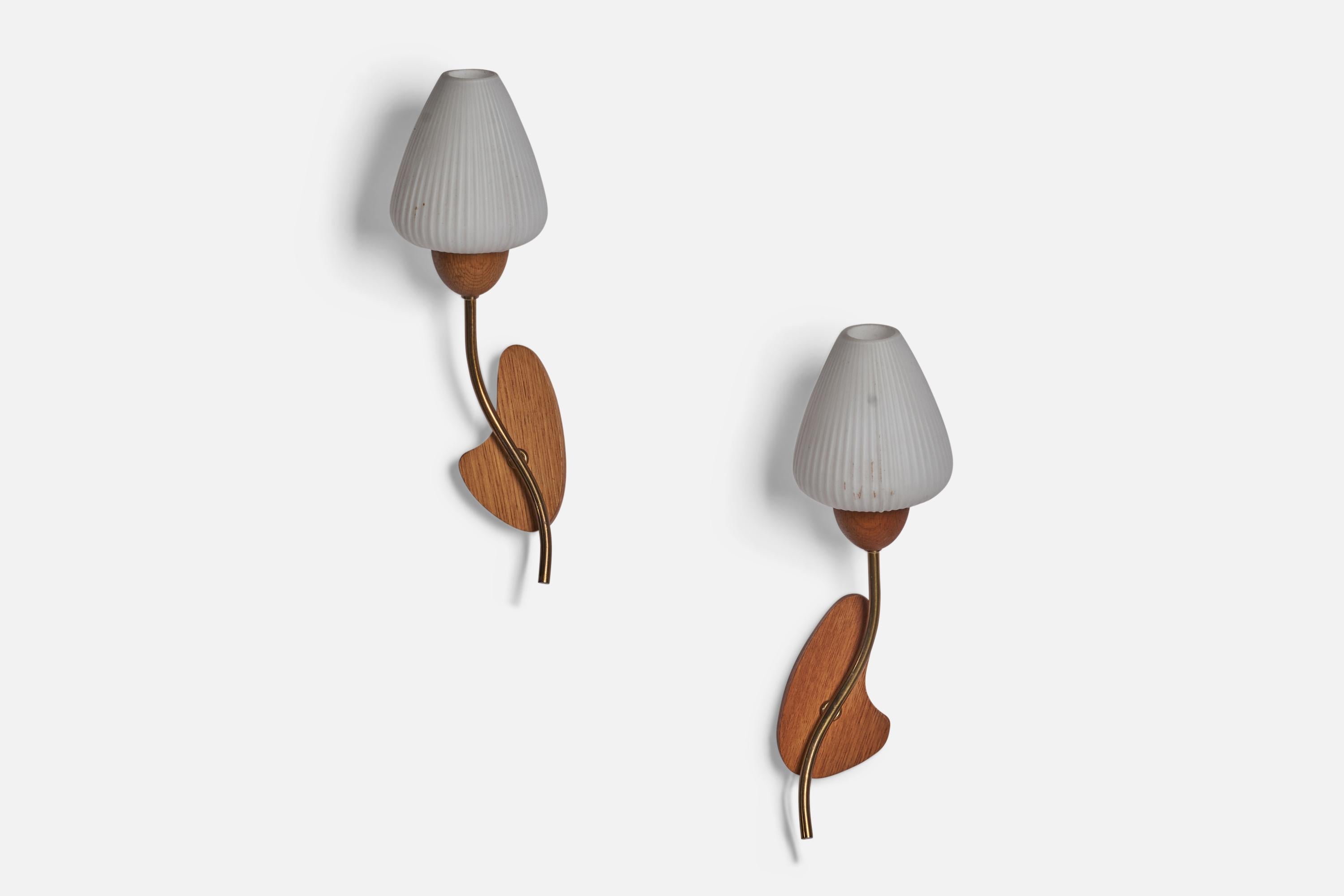 A pair of organic brass, teak and opaline glass wall lights designed and produced in Sweden, c. 1950s.

Overall Dimensions (inches): 13” H x 4.5” W x 4” D
Back Plate Dimensions (inches): 4.75” H x 2.6” W x 0.75” D
Bulb Specifications: E-14