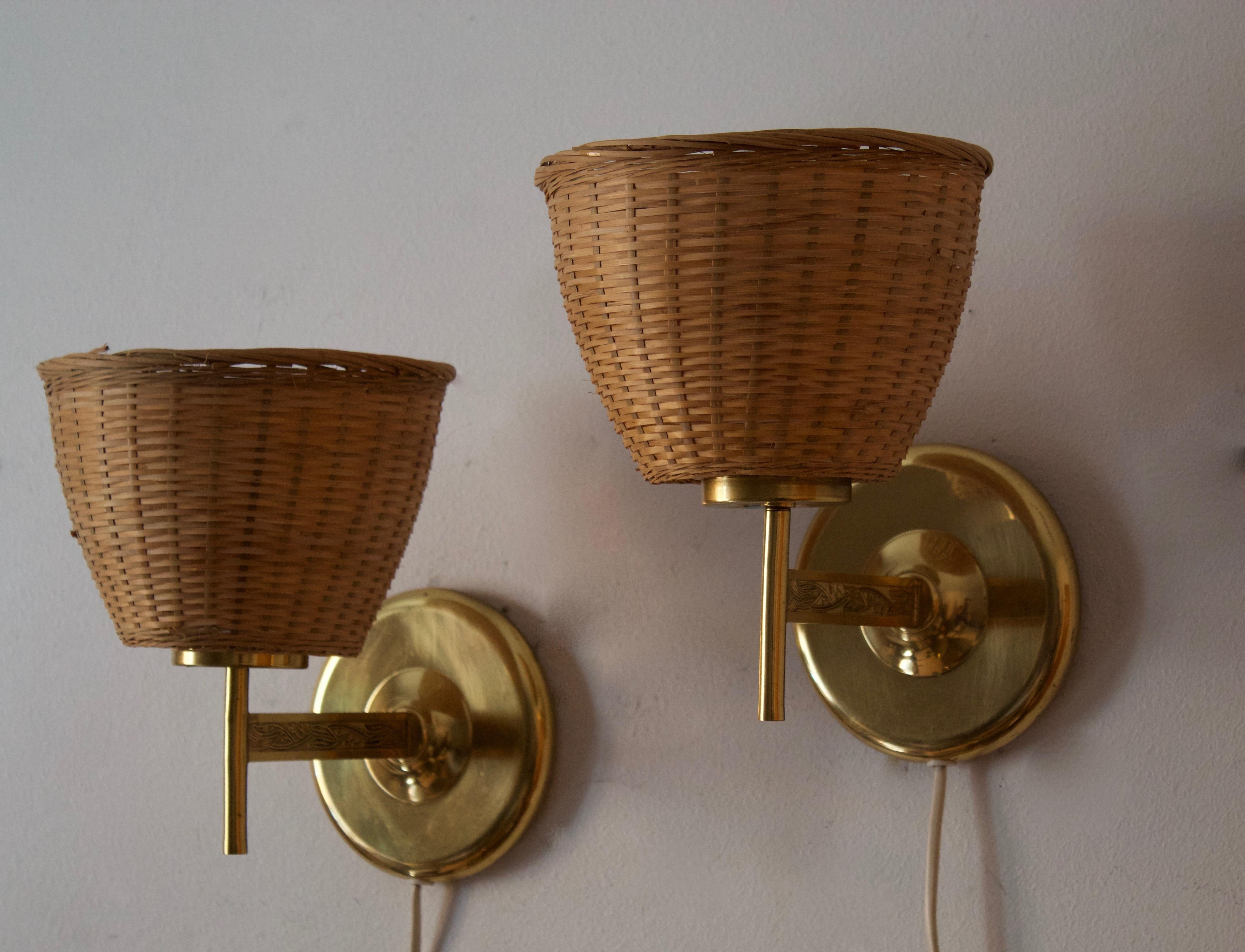 A pair of wall lights, designed and produced in Sweden, c. 1950s-1960s. Features brass, assorted vintage lampshades.

Stated dimensions with lampshade attached.