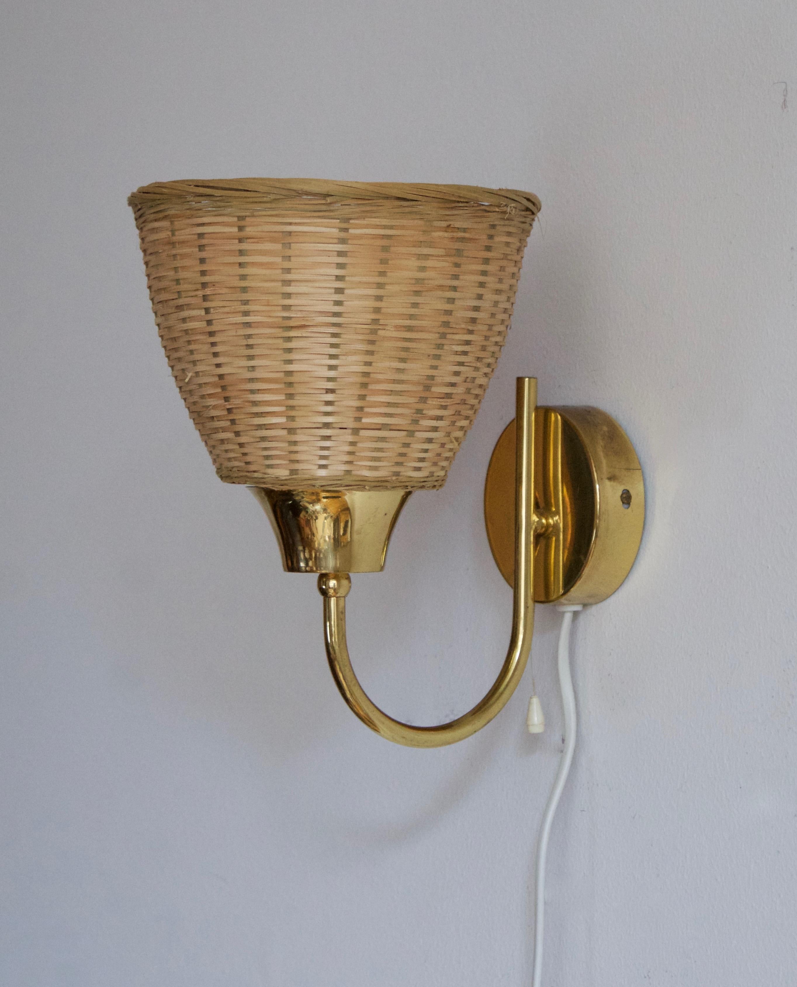 A pair of wall lights, designed and produced in Sweden, c. 1950s-1960s. Features brass, assorted vintage lampshades.

Stated dimensions with lampshade attached.