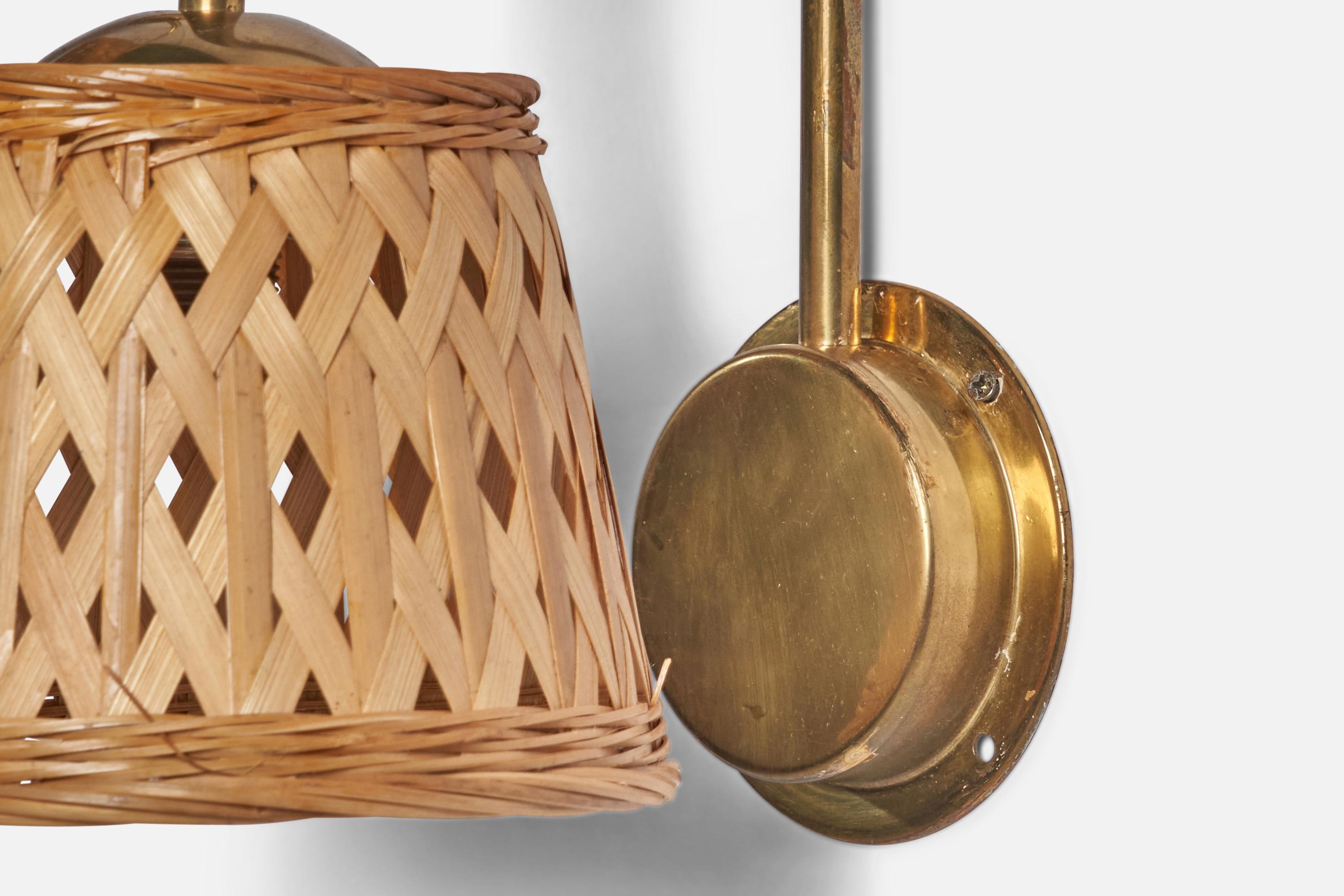 A pair of brass and rattan wall lights designed and produced in Sweden, c. 1970s.

Overall Dimensions (inches): 10” H x 7.25” W x 10” D

Back Plate Dimensions (inches): 4.25” Diameter

Bulb Specifications: E-14 Bulb

Number of Sockets: 1

All