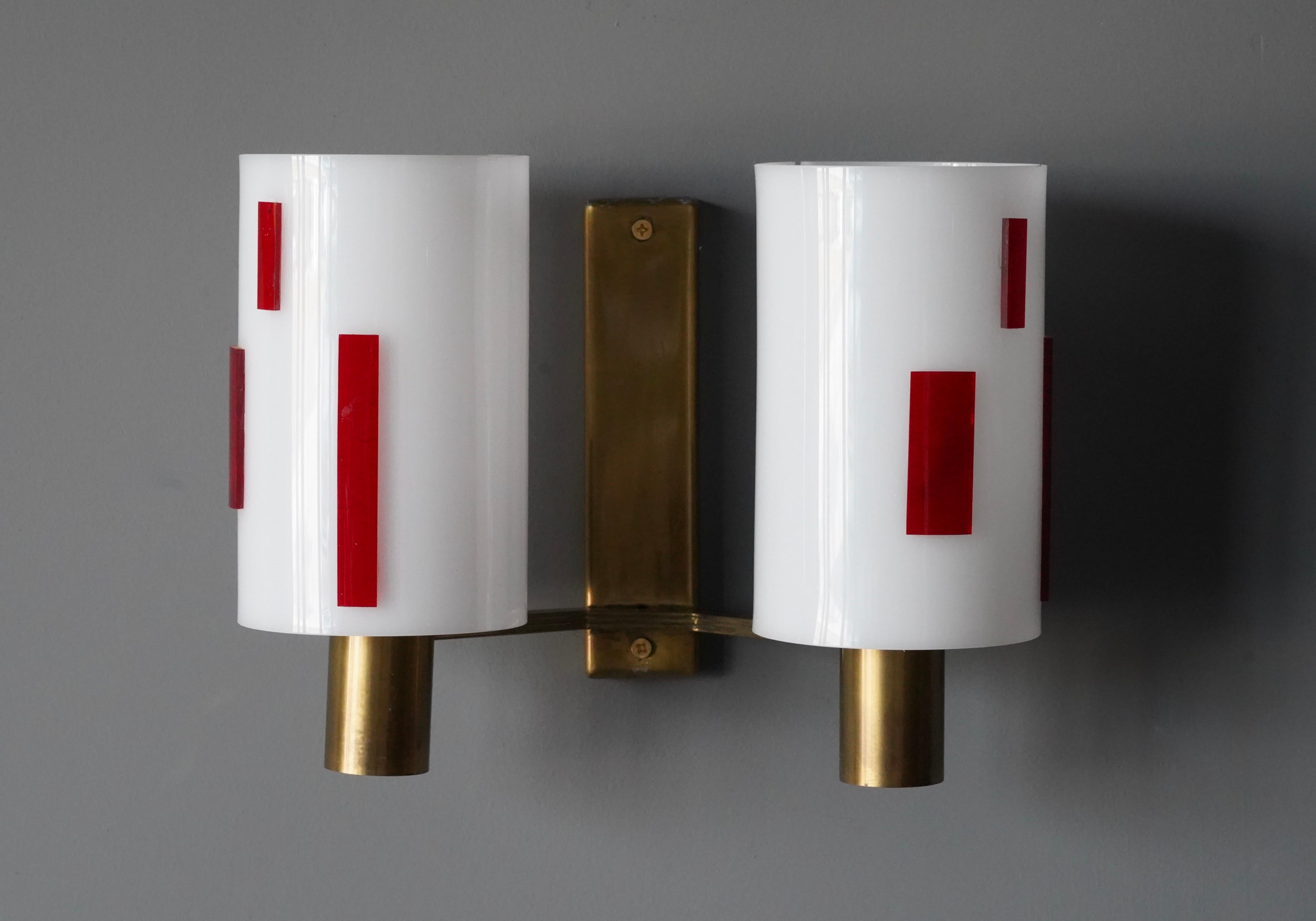 A pair of two-armed wall lights. Designed and produced in Sweden, c. 1960s. Features brass and white acrylic lampshades. With highly graphic contrastic red acrylic ornamentation.

No plug included. Hardwired only.