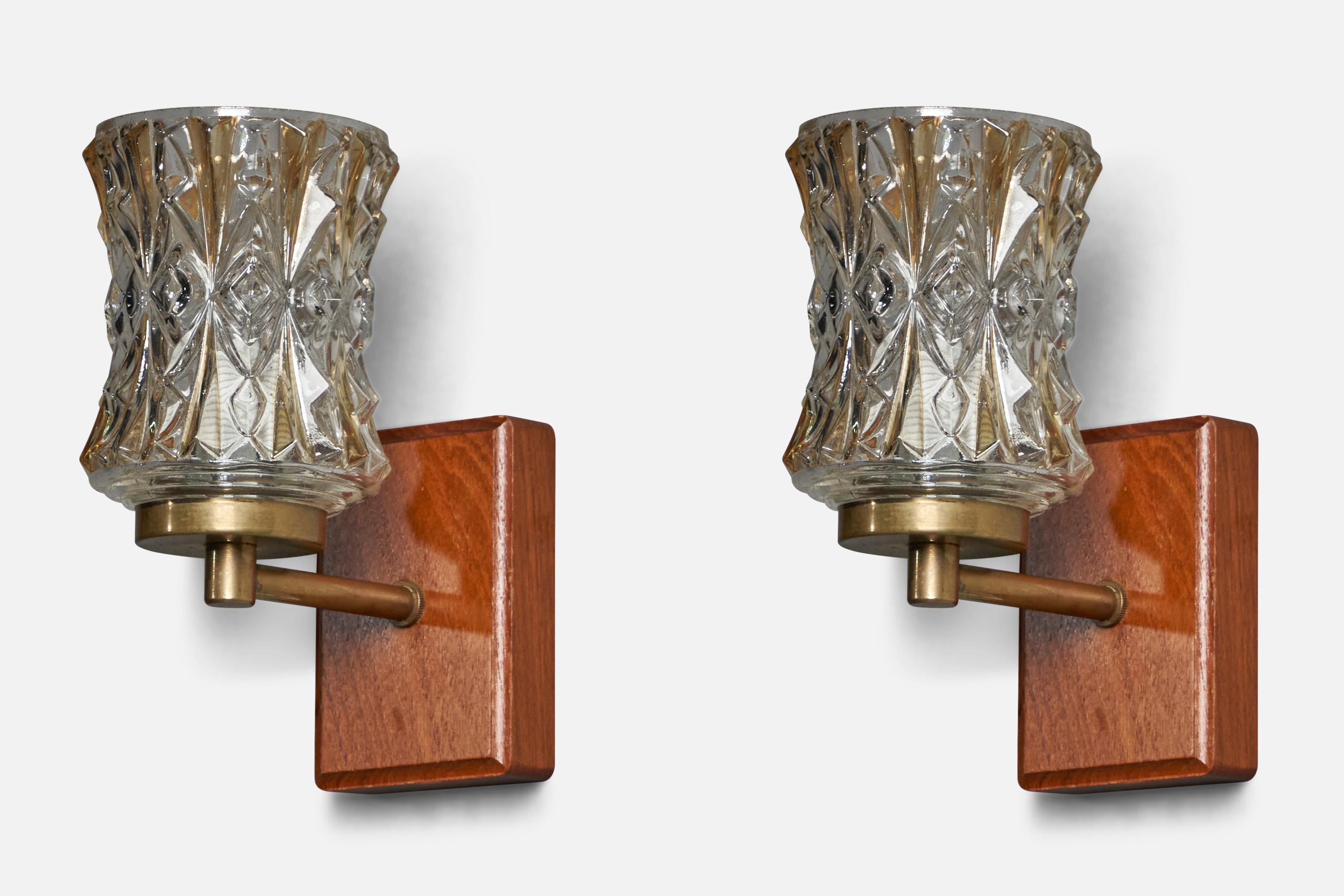 A pair of brass, glass and teak wall lights designed and produced in Sweden, c. 1950s.

Overall Dimensions (inches): 6.25” H x 2.85” W x 5.5” D
Back Plate Dimensions (inches): 3.9” H x 2.85” W x 0.9” D
Bulb Specifications: E-14 Bulb
Number of