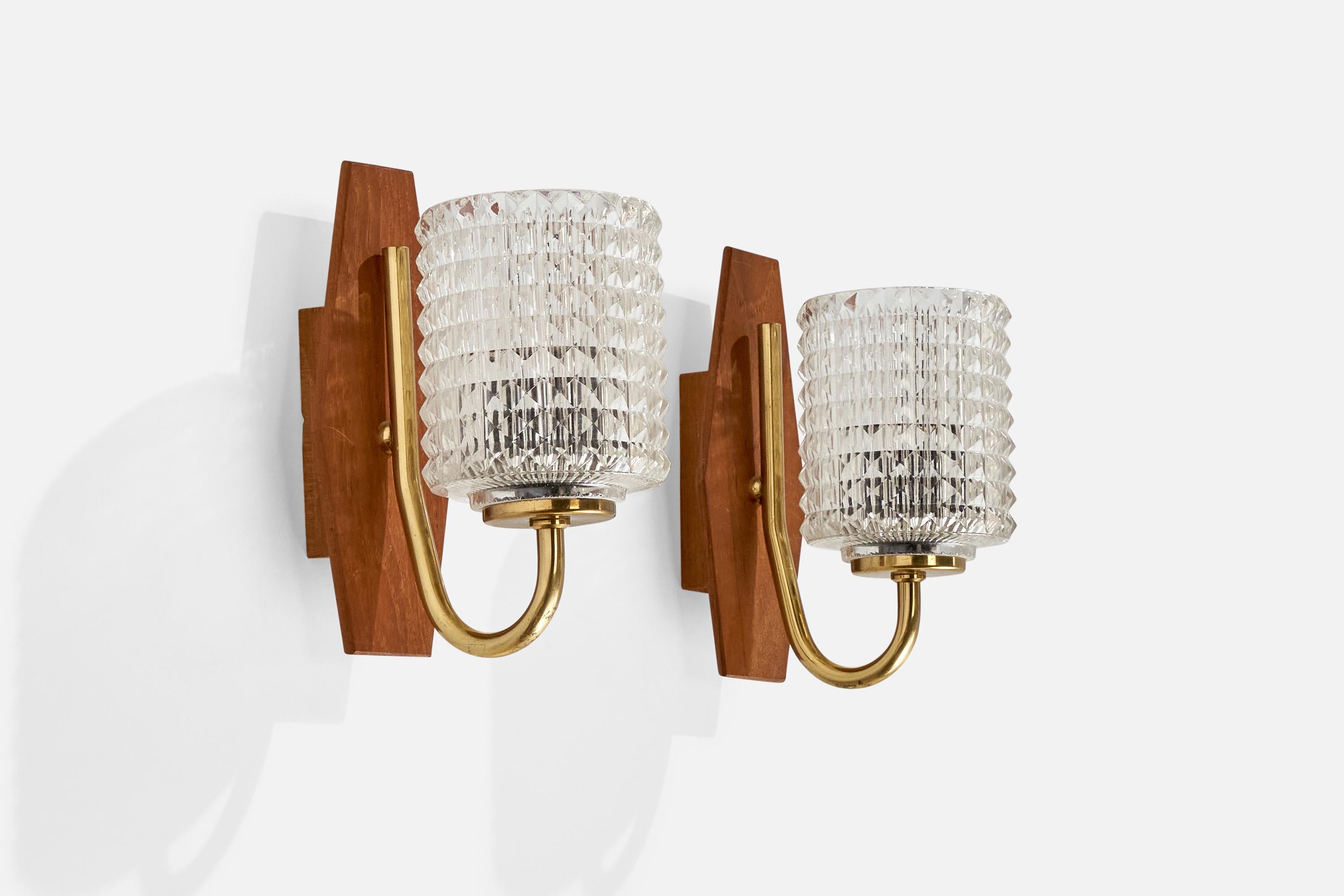 A pair of brass, teak and glass wall lights designed and produced in Sweden, c. 1950s.

Overall Dimensions (inches):  7.25” H x 3.25 ” W x  5.25“D
Back Plate Dimensions (Inches):  7” H x 3” W x 1” D
Bulb Specifications: E-12 Bulbs
Number of Sockets