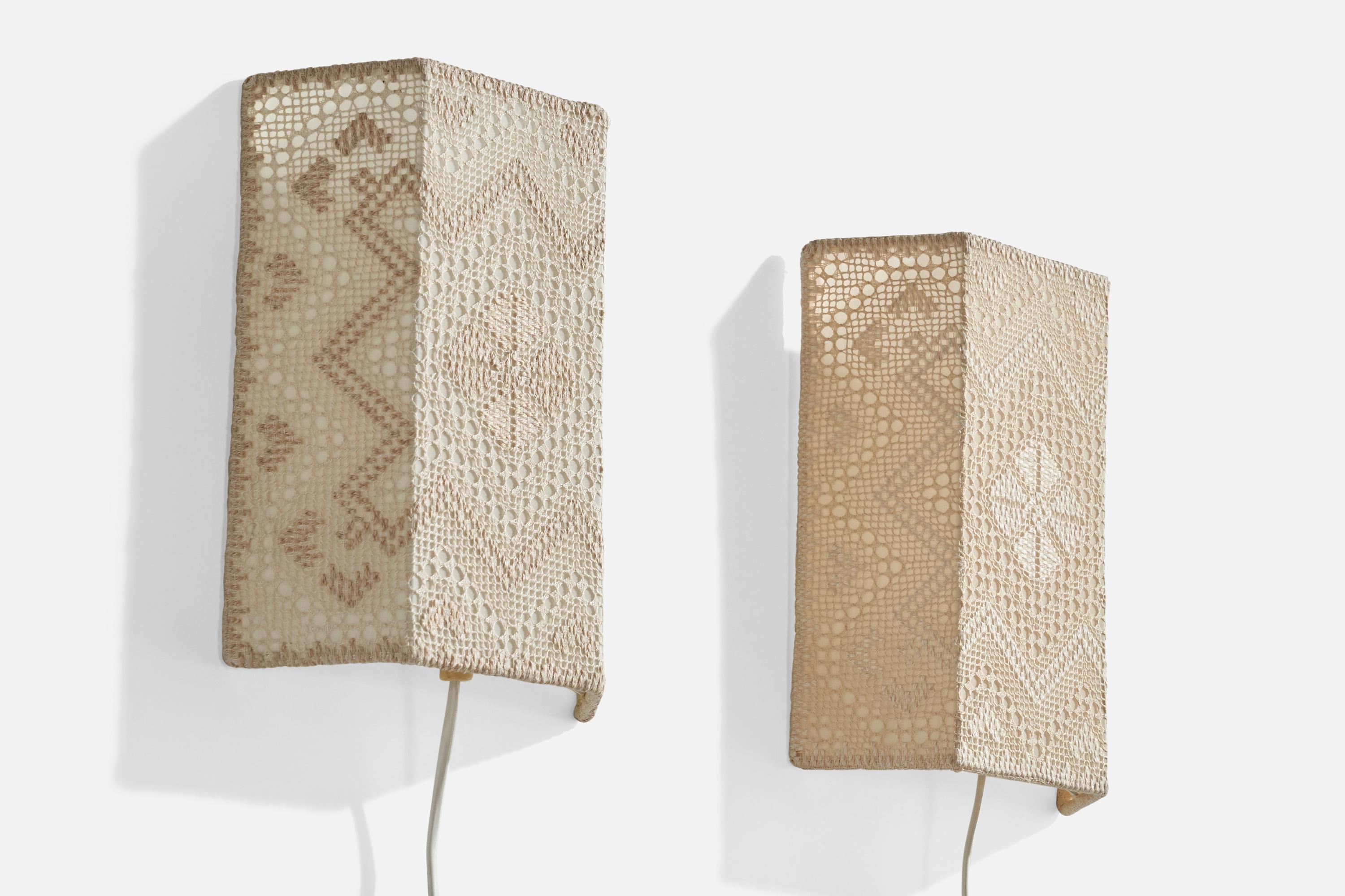 Paire d'appliques en tissu de broderie et en métal conçues et produites en Suède, vers les années 1960.

La variance est l'exécution de la broderie pour chaque exemple, comme illustré.

Dimensions globales (pouces) : 10