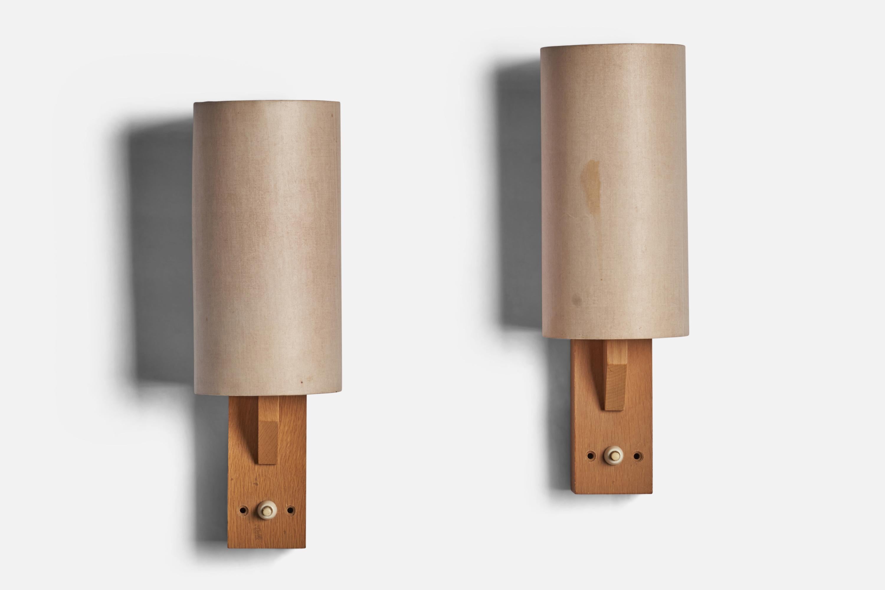 A pair of oak and off-white paper wall lights designed and produced in Sweden, 1970s.

Overall Dimensions (inches): 13.25” H x 4.5” W x 4.75” D
Back Plate Dimensions (inches): 4.6” H x 2.45” W
Bulb Specifications: E-26 Bulb
Number of Sockets: 1

All