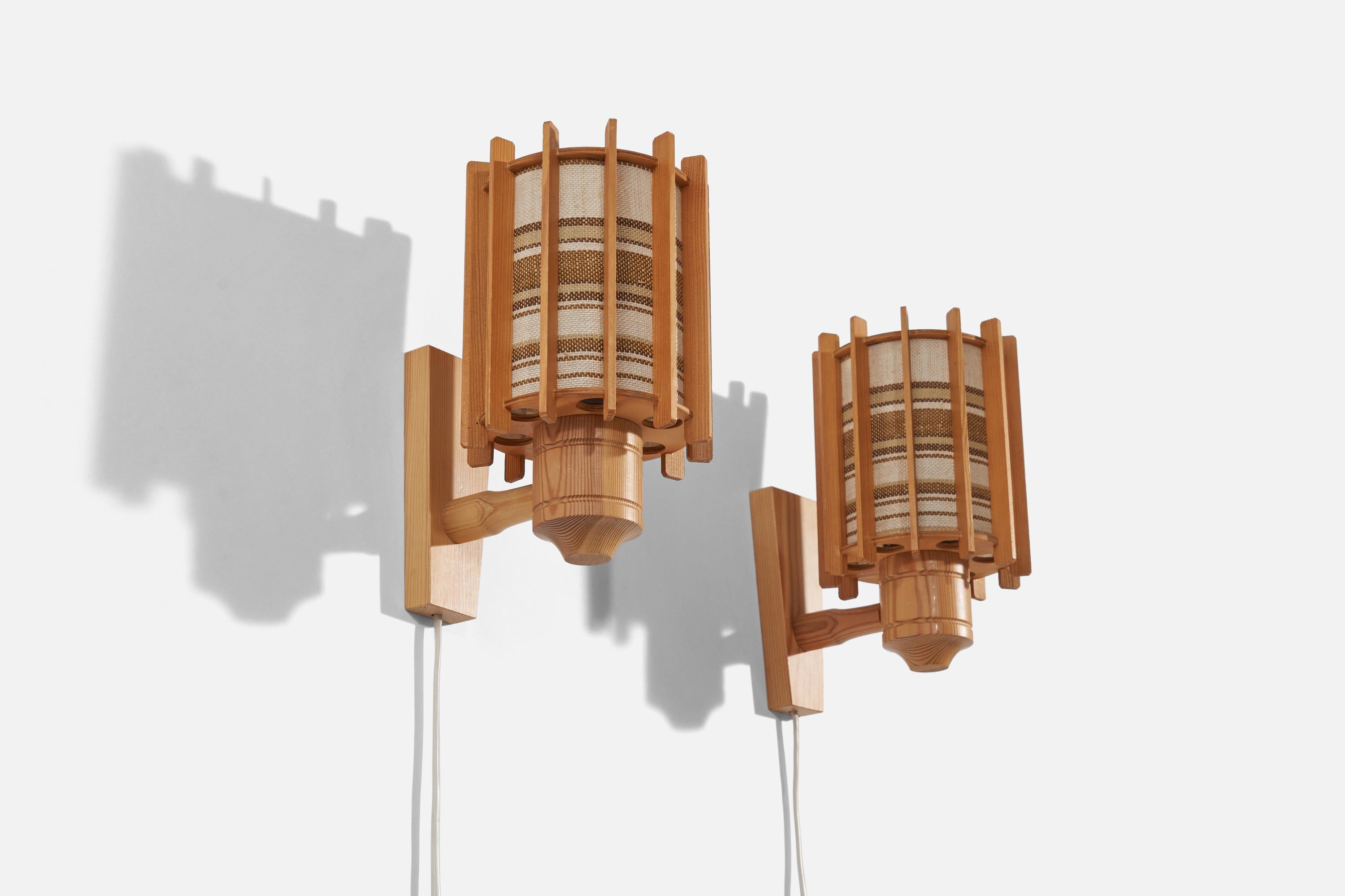 A pair of pine and fabric wall lights produced in Sweden, 1970s.