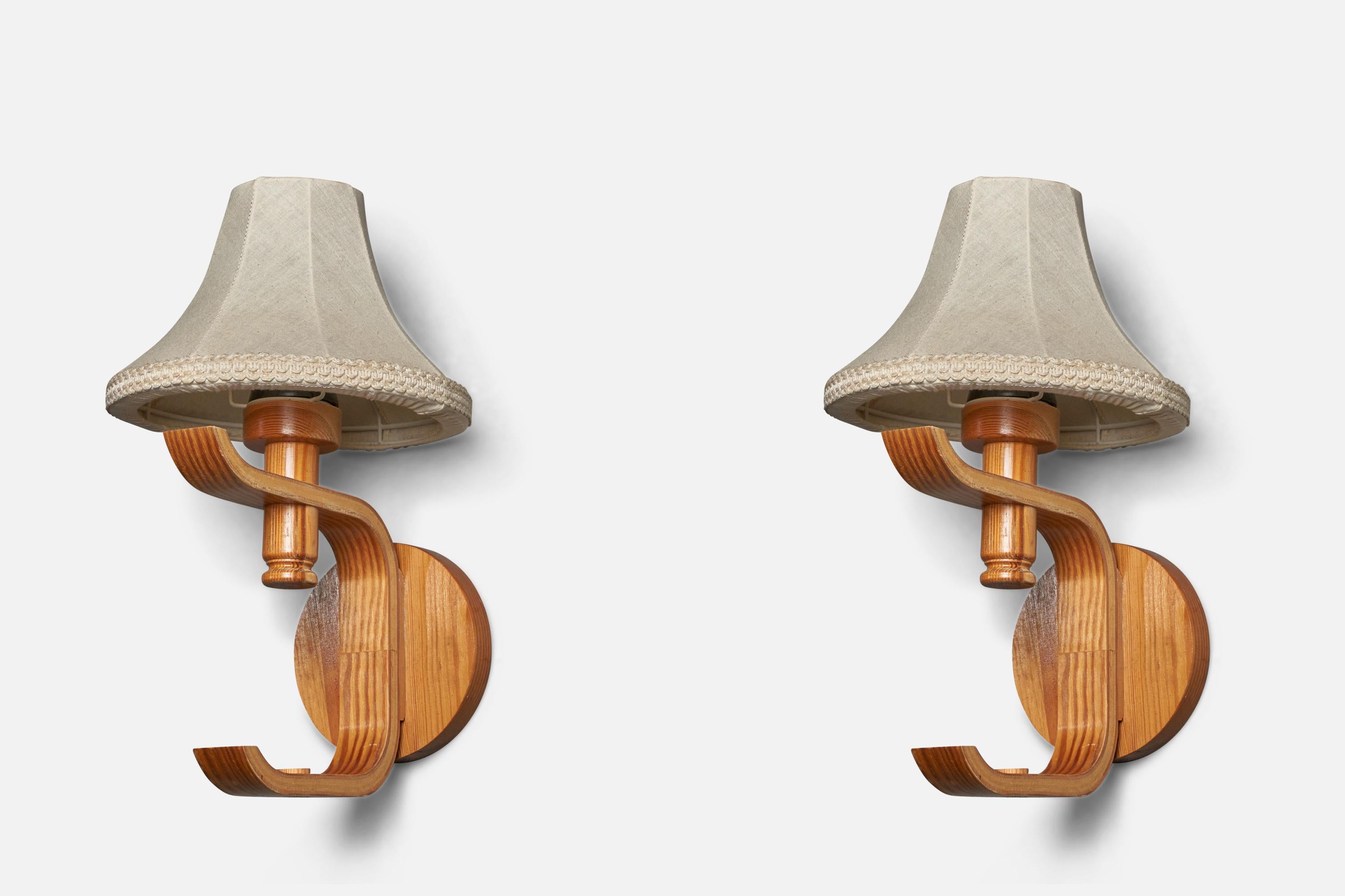 A pair of pine, moulded pine and off-white fabric wall lights designed and produced in Sweden, 1970s.

Overall Dimensions (inches): 15” H x 8.5” W x 8.75” D
Back Plate Dimensions (inches): 5.4” Diameter x 0.75” D 
Bulb Specifications: E-26