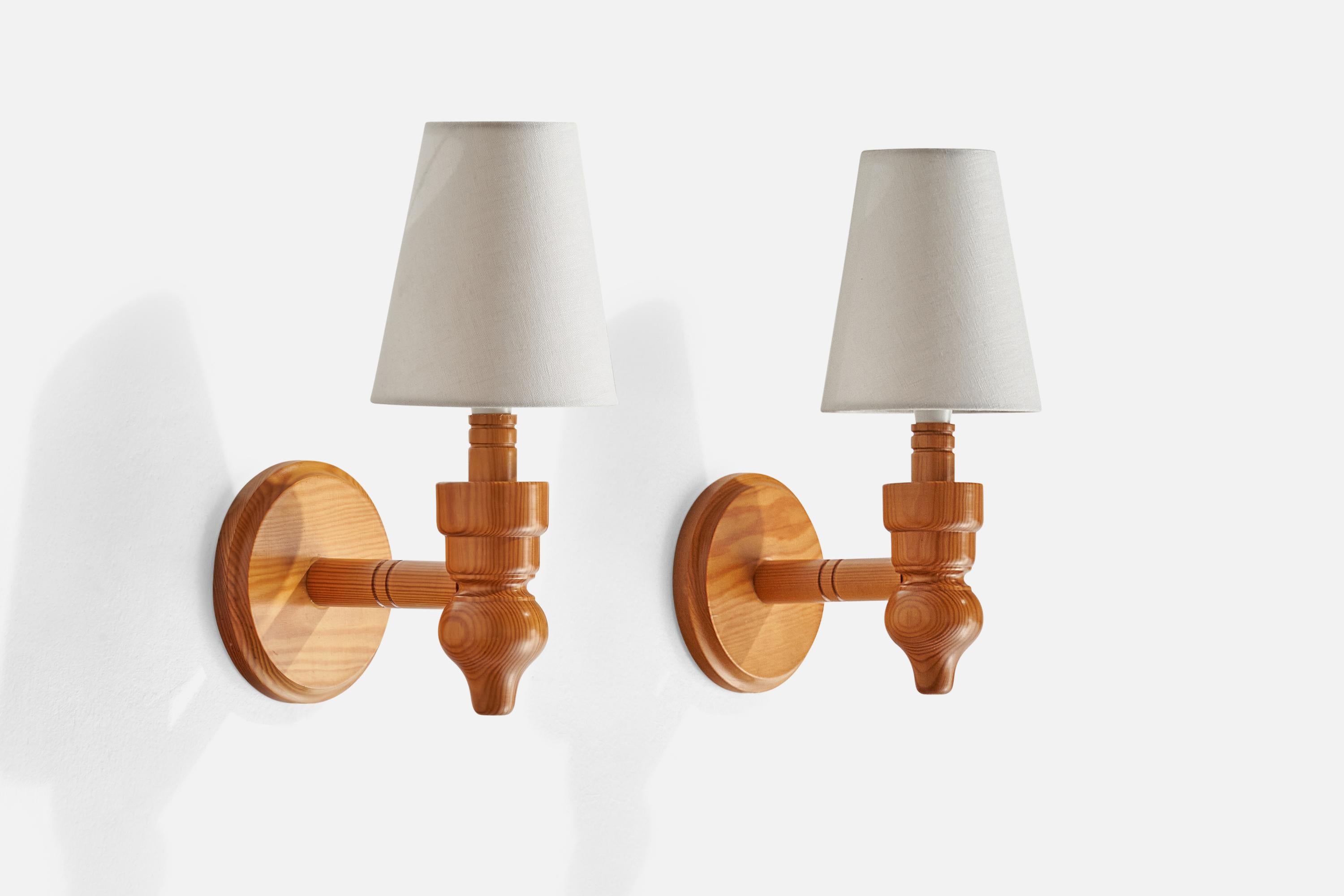 A pair of pine and white fabric wall lights designed and produced in Sweden, 1970s.

Overall Dimensions (inches): 6” H x 5” W x 6.75” D
Back Plate Dimensions (inches): 5.25” H x 5.25” W x .75” D
Bulb Specifications: E-14 Bulb
Number of Sockets: