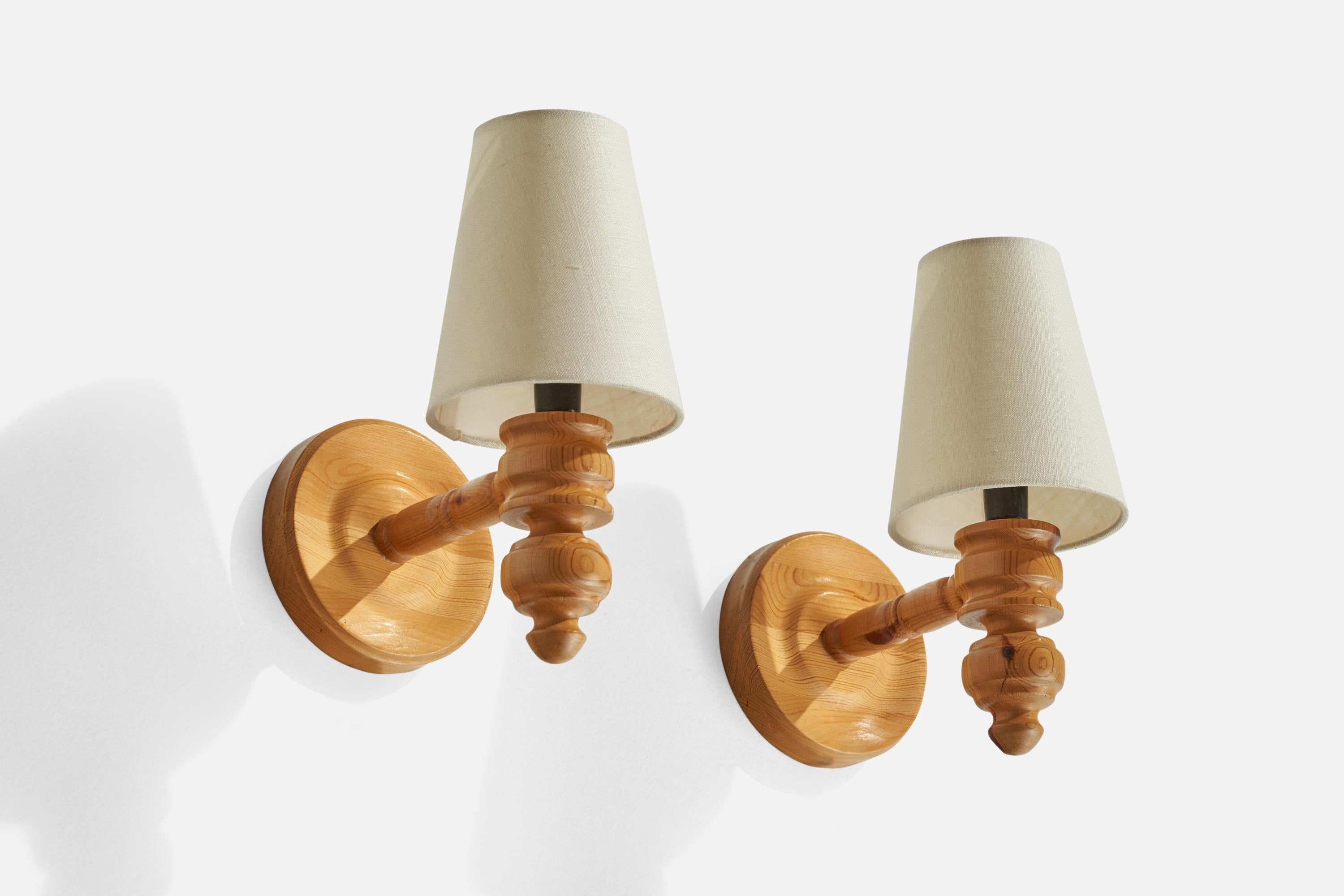A pair of pine and white fabric wall lights designed and produced in Sweden, 1970s.

Overall Dimensions (inches): 7” H x 5.25” W x 7.5” D
Back Plate Dimensions (inches): 5.26”H x 5.25” W x 1” D
Bulb Specifications: E-14 Bulb
Number of Sockets: 2
All